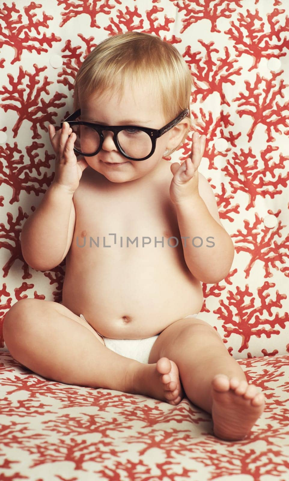 Smile, glasses and fun baby in studio with vision, eye care and health for child development. Happy, cute and young infant, toddler or kid playing with spectacles or eyewear by wallpaper background. by YuriArcurs