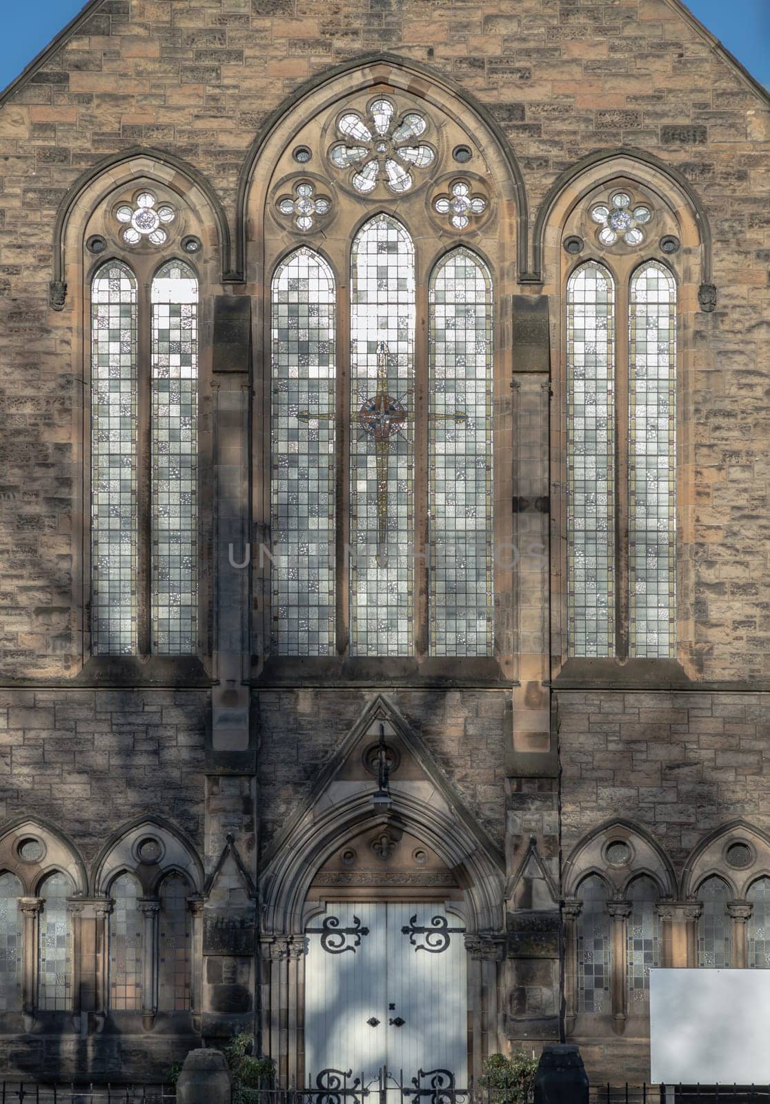 Edinburgh, Scotland-Jan 17, 2024 - The sunshine lights through the glass window frame and old wall Exterior architecture of The cathedral Church. Space for text, Selective focus.