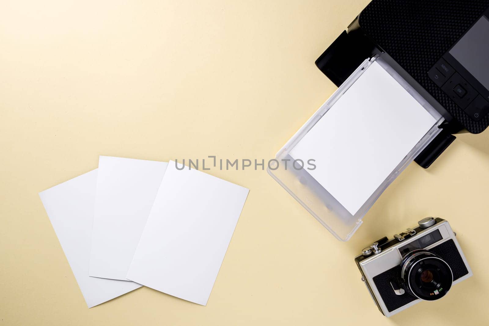 Top view of retro camera, blank photo papers and mobile photo printer