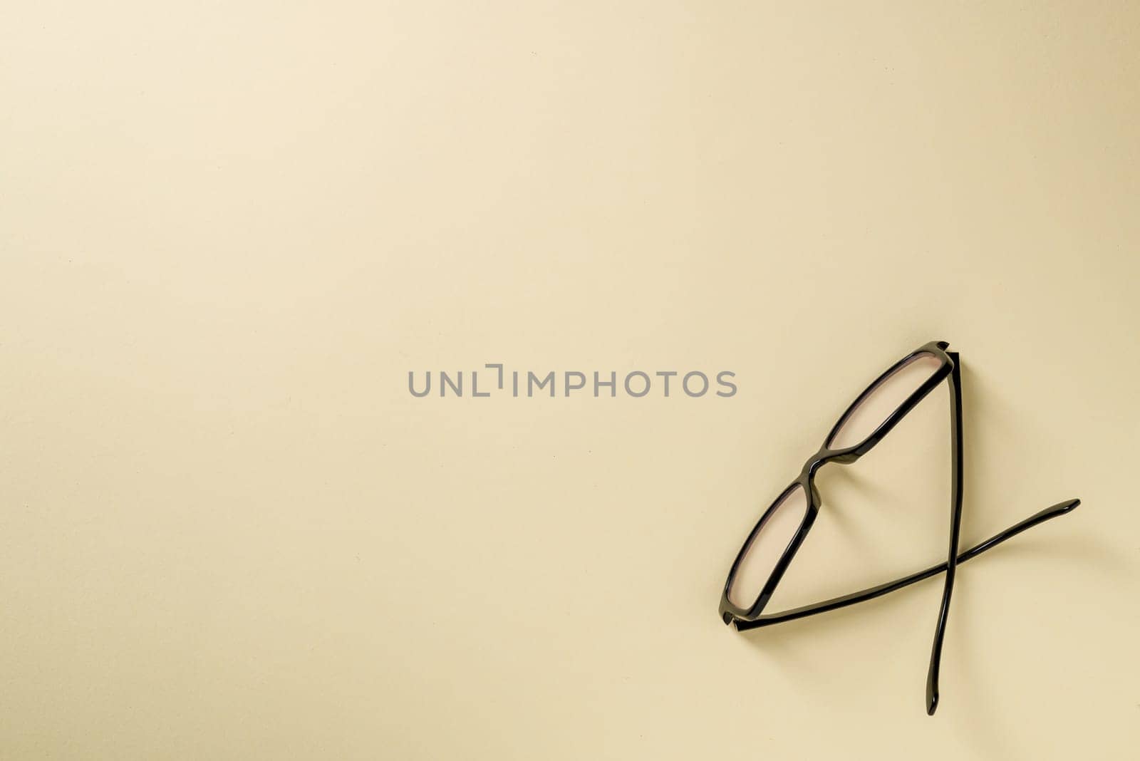 Prescription glasses with black frames on a yellow background by Sonat