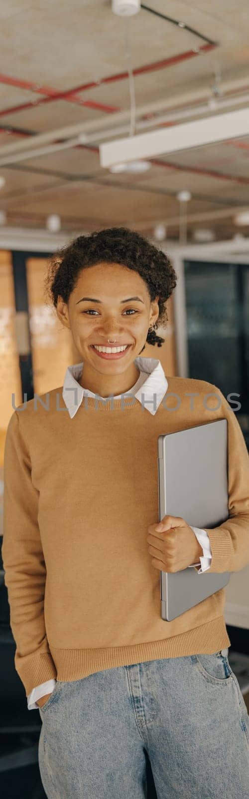 Female manager with laptop standing on background of modern office. High quality photo