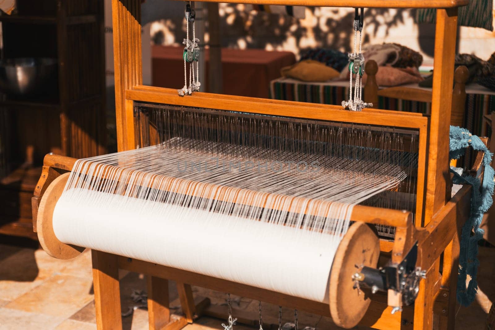 Master weaver is weaving the tapestry with diverse bright threads, close up. Artisanal at work.