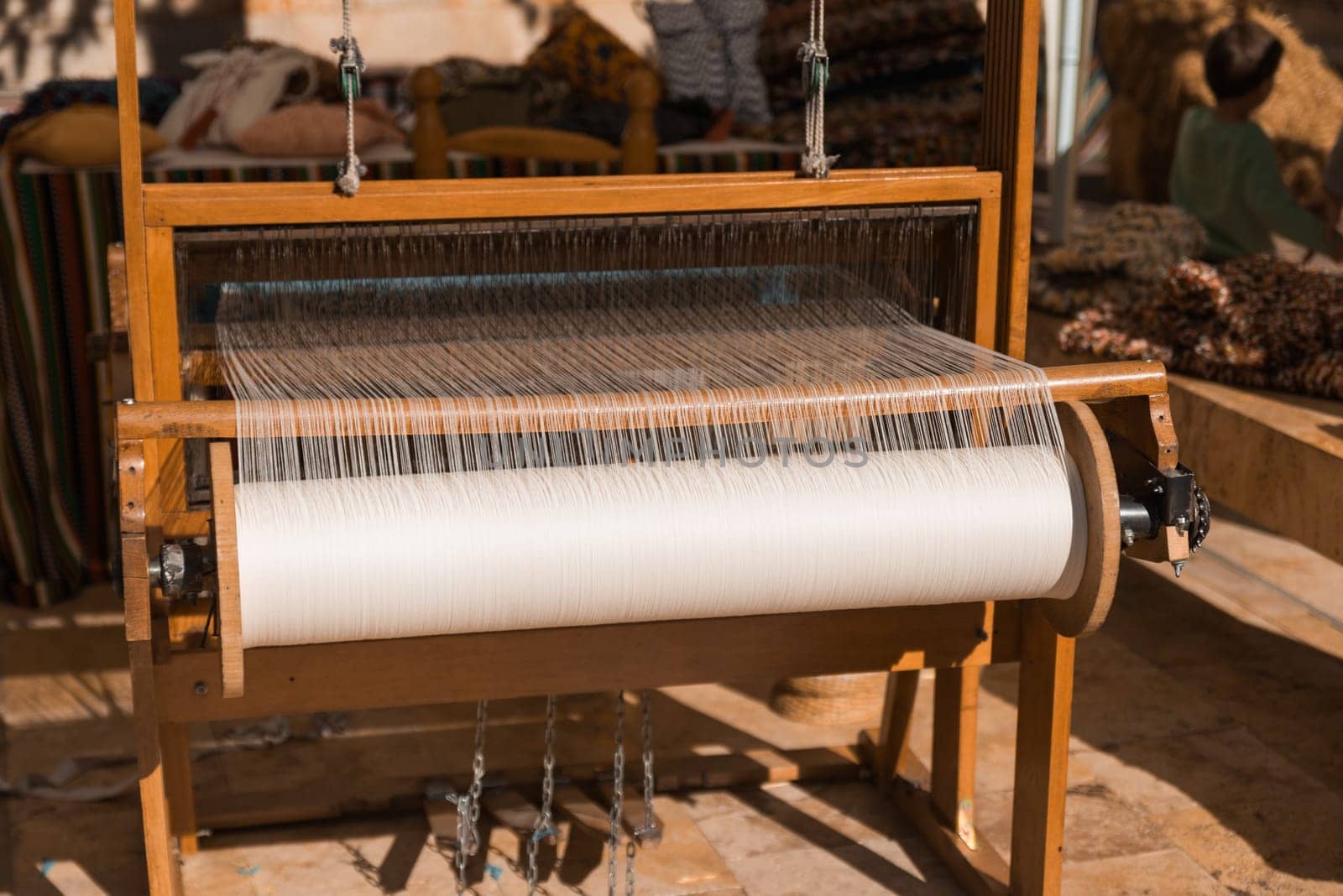 Master weaver is weaving the tapestry with diverse bright threads, close up. Artisanal at work by jcdiazhidalgo