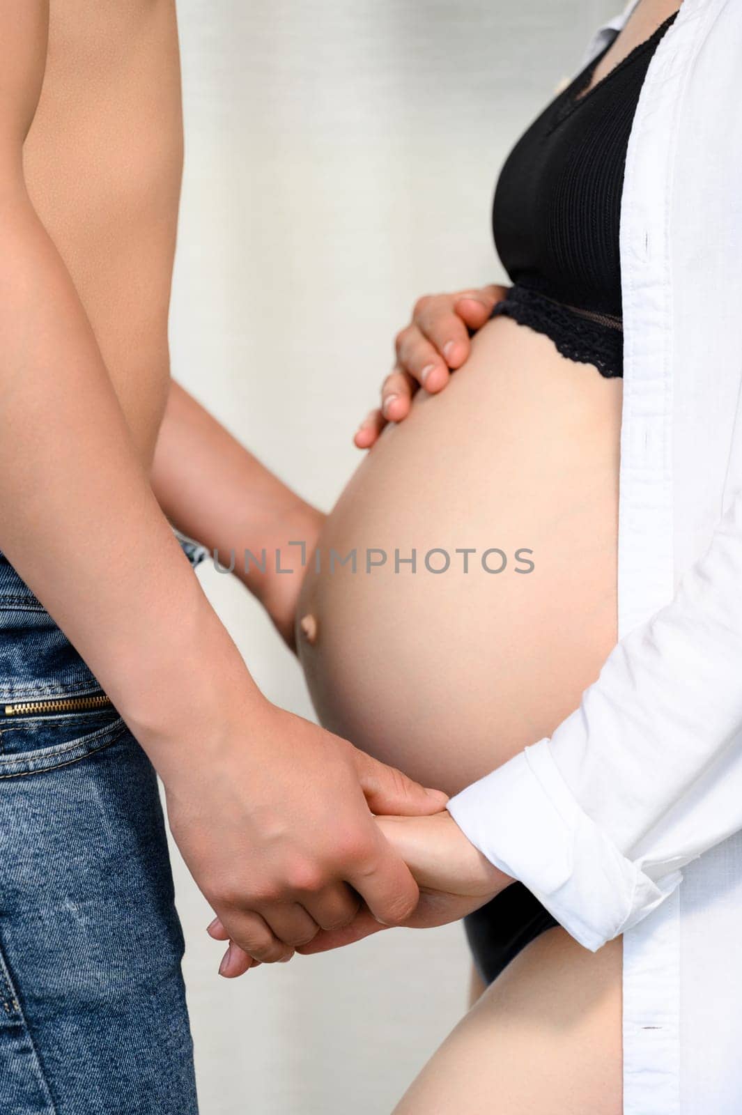 A pregnant woman's belly is exposed, a married couple is waiting for the birth of their child. by Niko_Cingaryuk