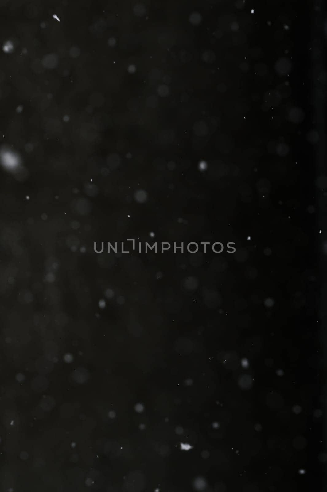 Bokeh of white snow on a black background. Snowfall - design element. by Niko_Cingaryuk