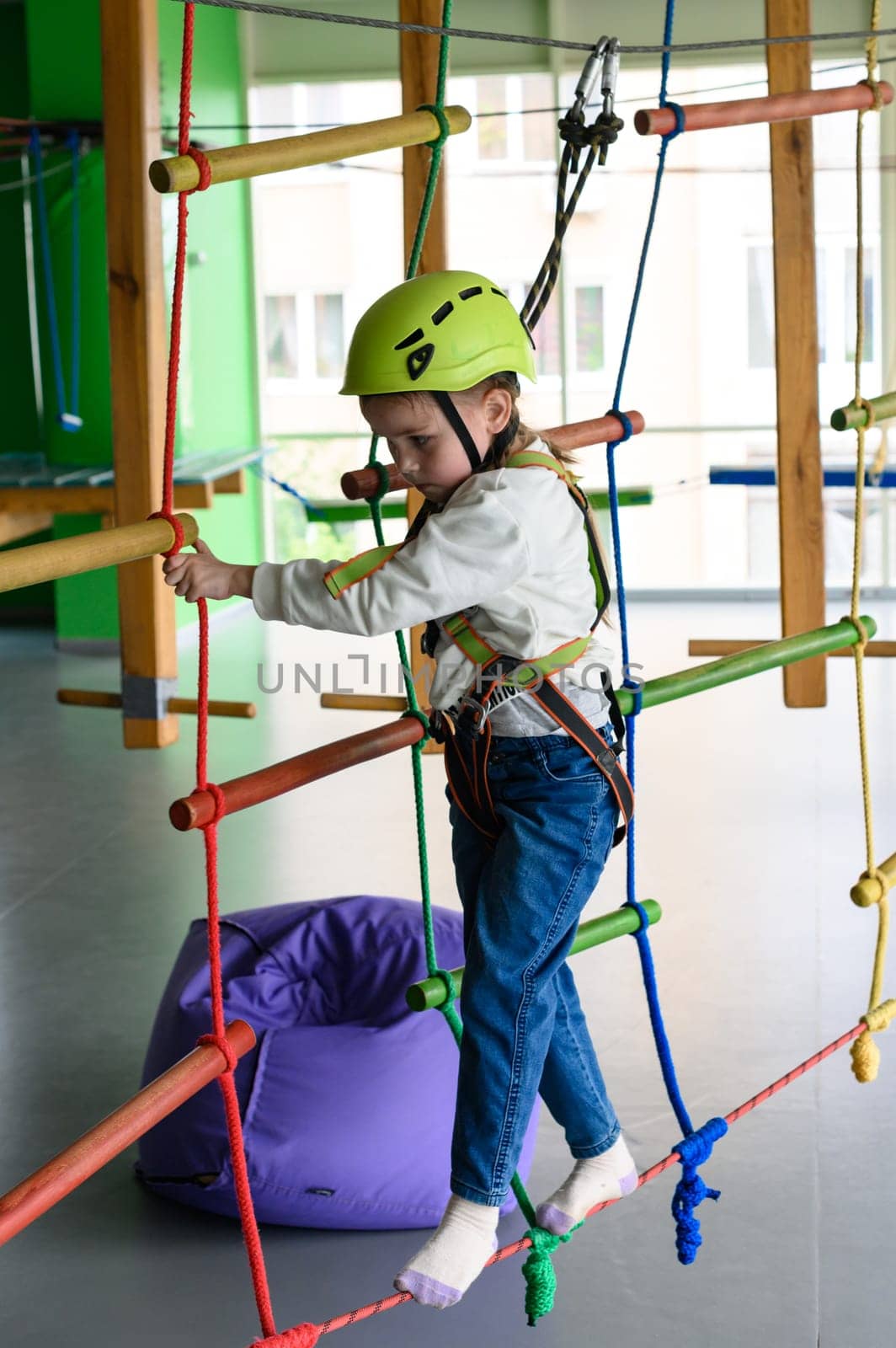active and physical development of the child, the girl passes the cableway in the playroom.