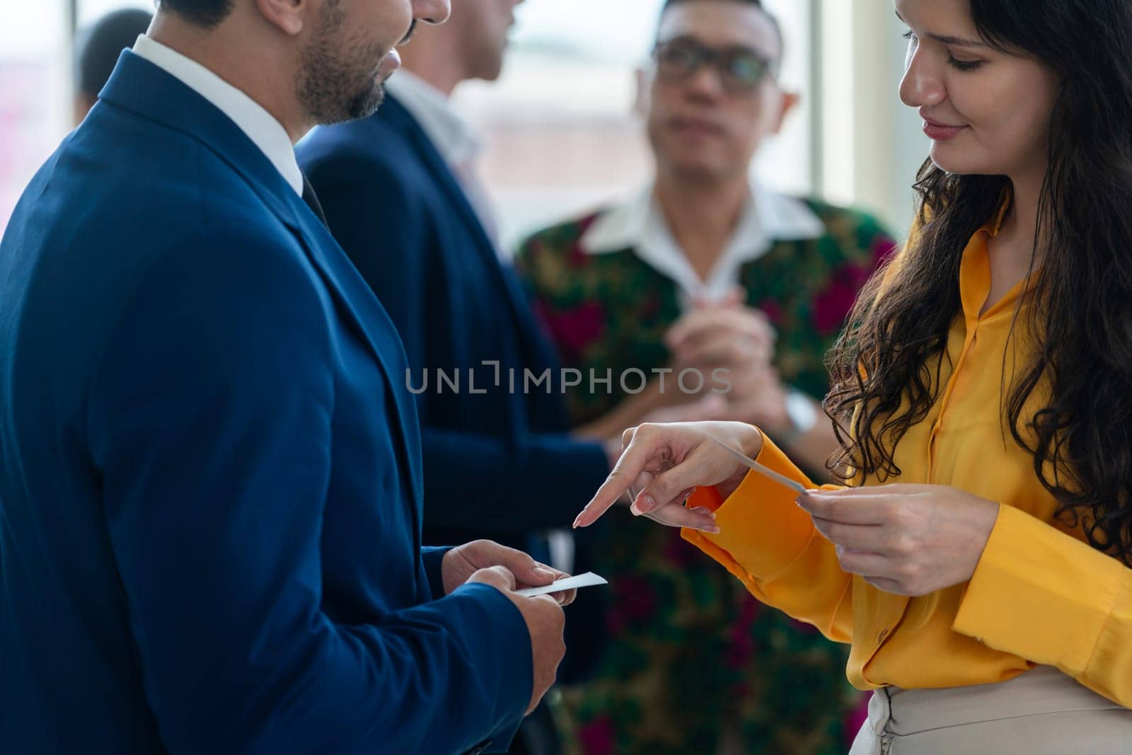 Successful businesswoman holding the name card during talking to manager about their cooperation. Cropped image of exchanging name card between businessman and businesswoman. Side view. Intellectual.
