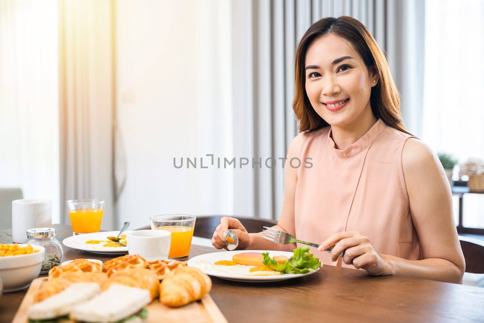 Asian young woman sitting kitchen table food having eating healthy breakfast at home by Sorapop