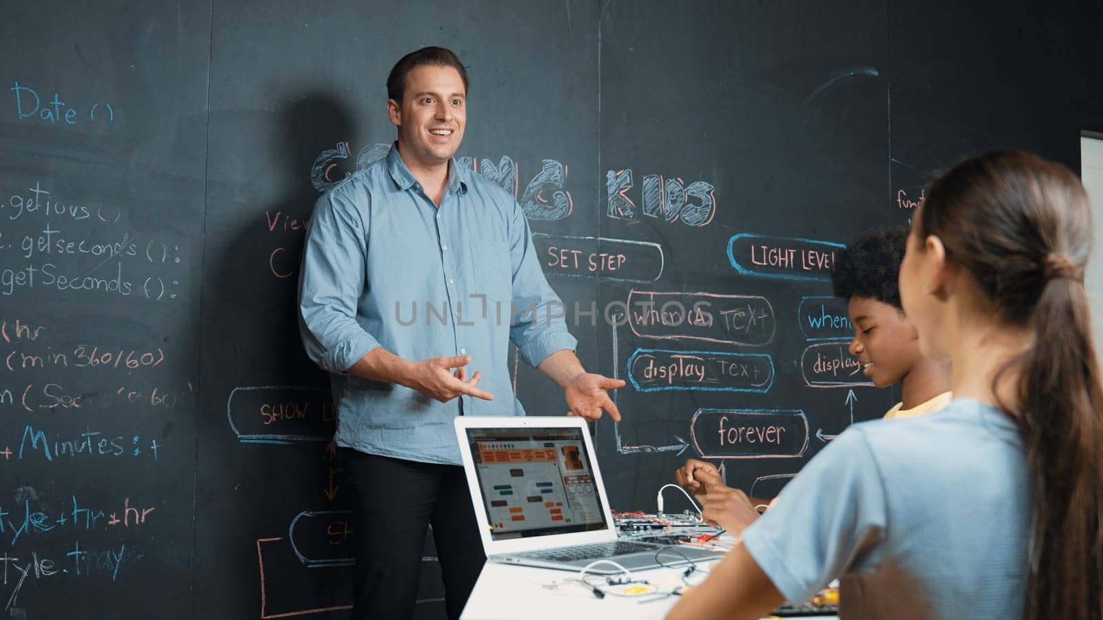 Happy caucasian teacher clap hands to applause student to encourage coding or programing prompt. Diverse student clapping hands to celebrate successful project while attend in STEM class. Edification.