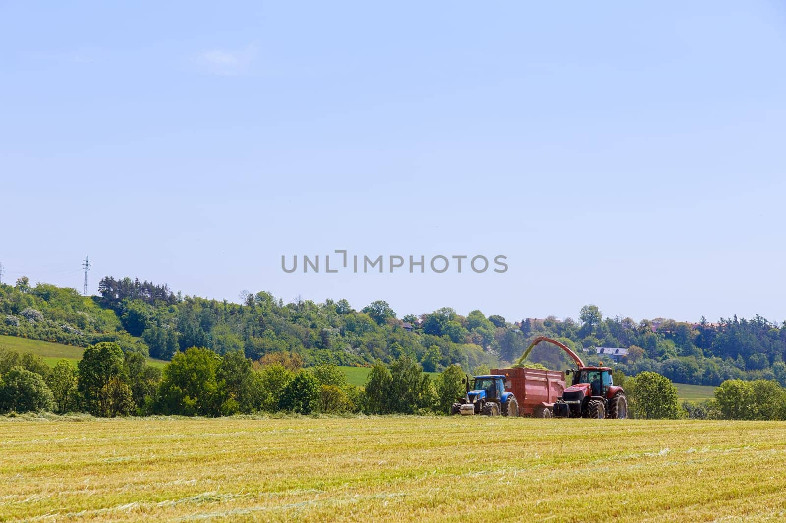 Forage harvester, cuts silage in the field and fills the tractor trailer. by Yaroslav