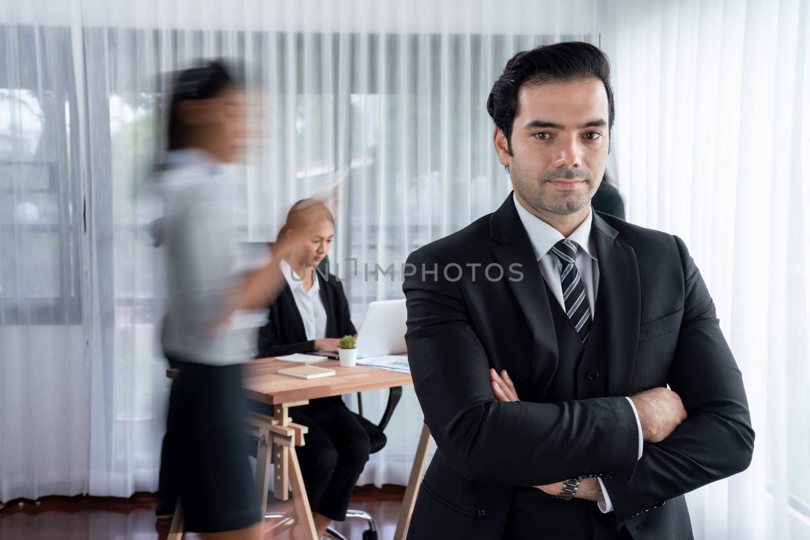 Portrait of happy businessman looking at camera with motion blur background of business people movement in dynamic business meeting. Habiliment