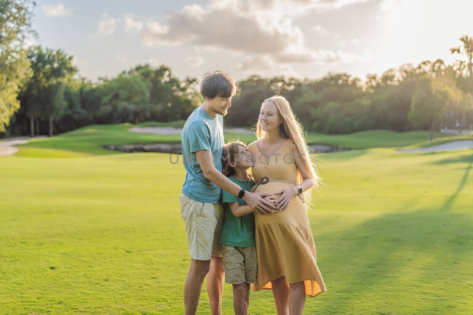 Joyful family time as a pregnant woman, her husband, and son share quality moments outdoors, embracing the beauty of nature and creating cherished memories together.