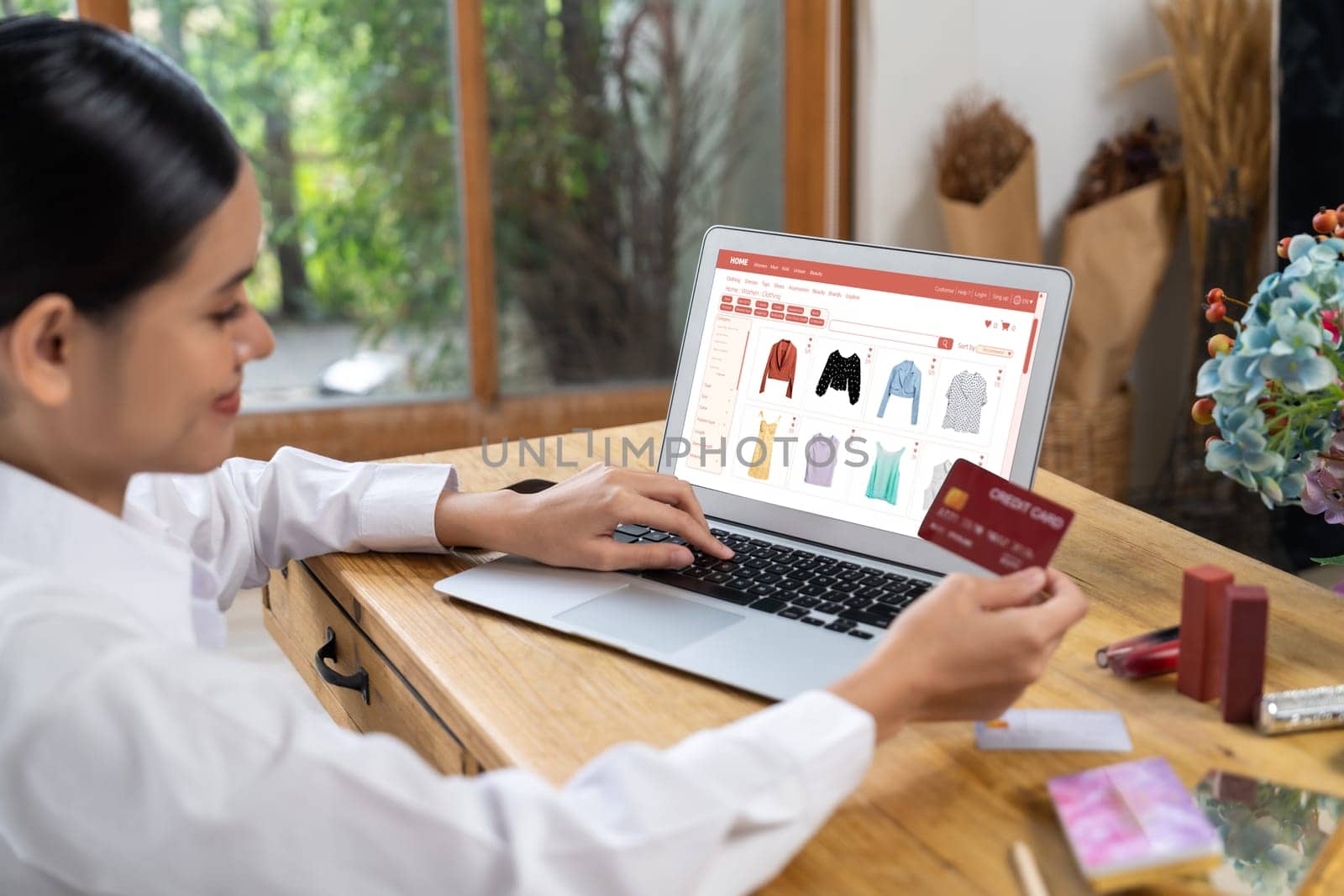 Woman shopping online on internet marketplace browsing for sale items for modern lifestyle and use credit card for online payment from wallet protected by uttermost cyber security software