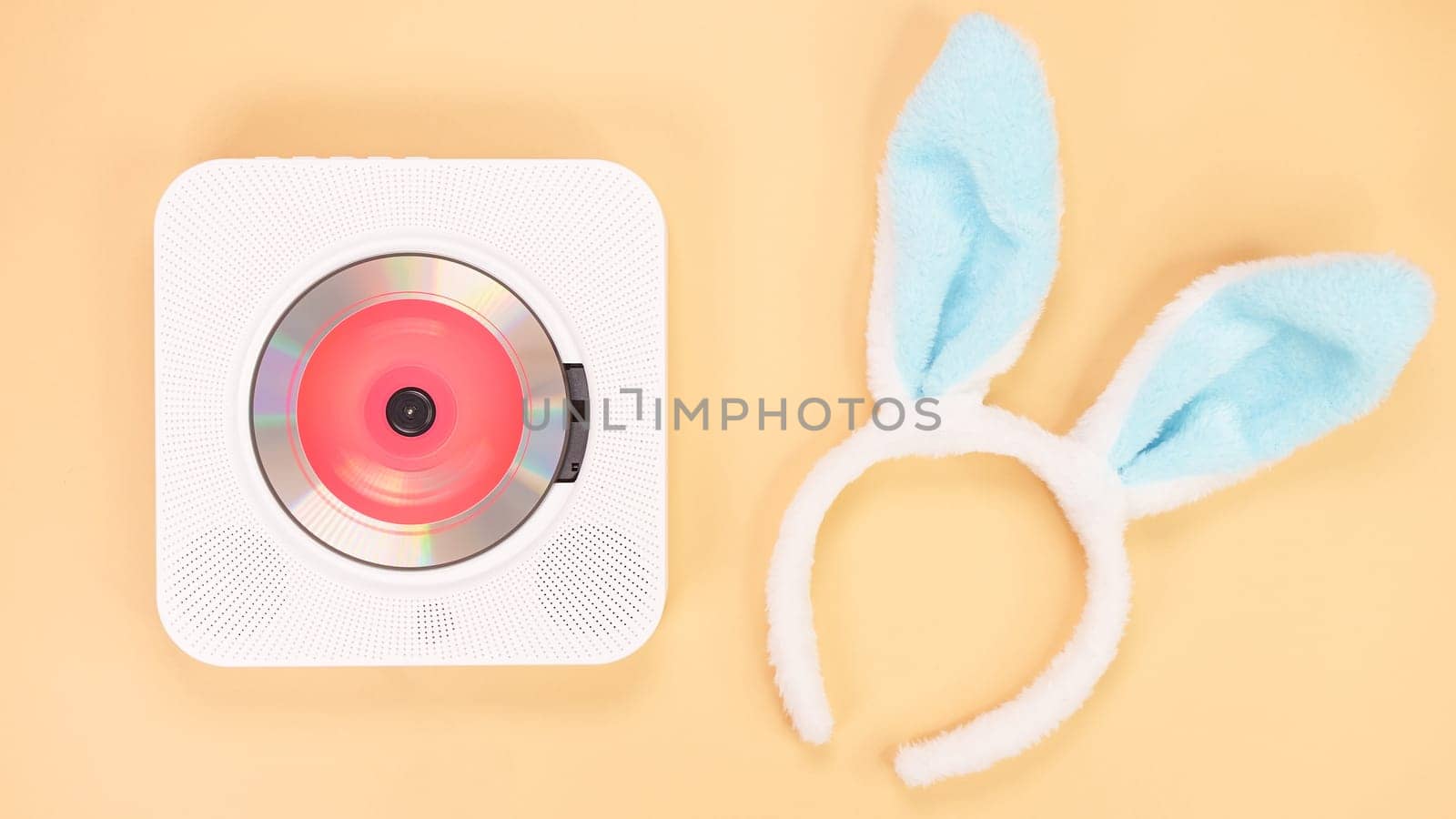 White cd player with red disc with bunny ears on yellow background. Love music, Easter bunny, retro Love song, space for text