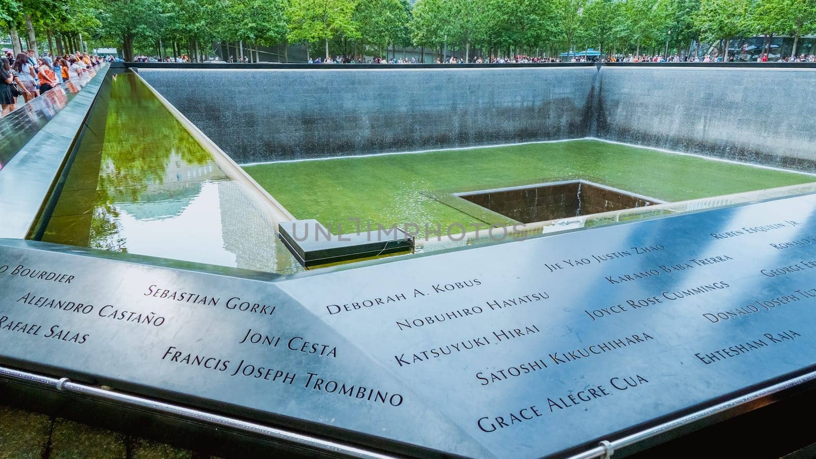 People at Ground Zero Memorial Manhattan for September 11 Terrorist Attack with Engraved Names of Victims. Patriot Day - New York NY USA 2023-07-30.