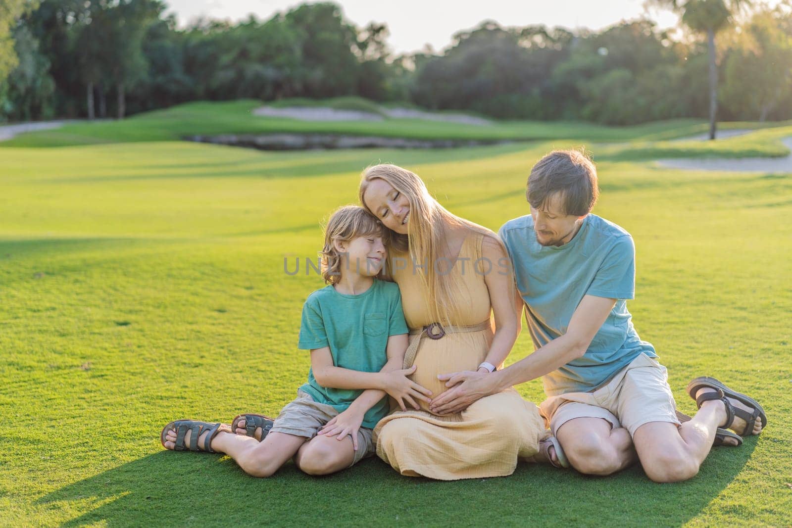 Joyful family time as a pregnant woman, her husband, and son share quality moments outdoors, embracing the beauty of nature and creating cherished memories together.