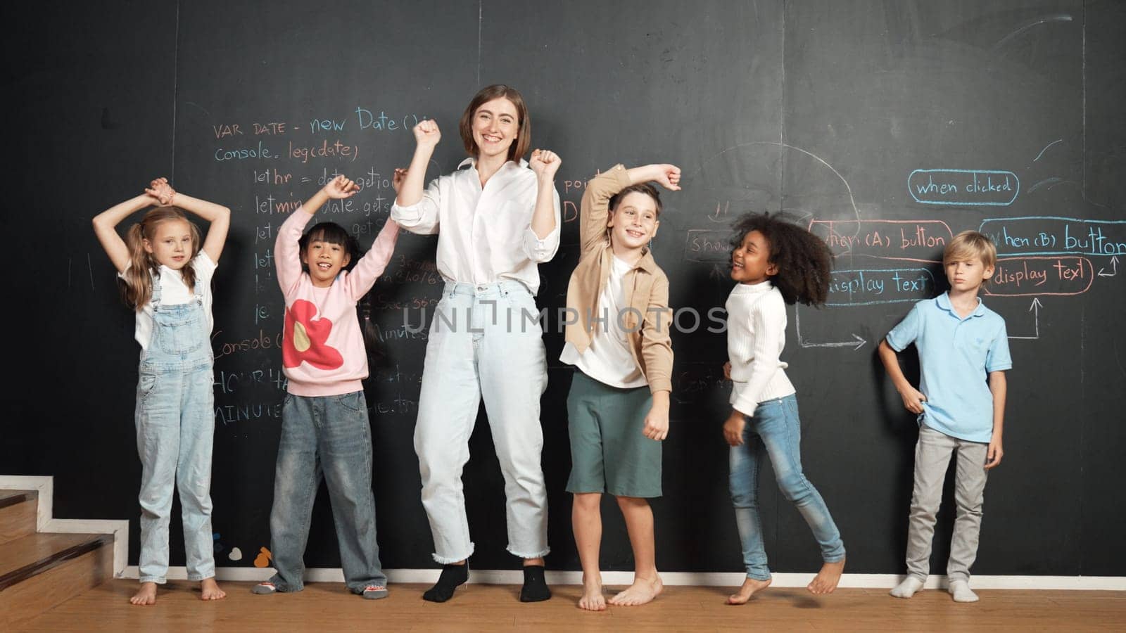 Multicultural happy student and teacher smiling and standing at blackboard with engineering code or prompt written. Kid express feeling of happy and enjoy with studying in STEM classroom. Erudition.