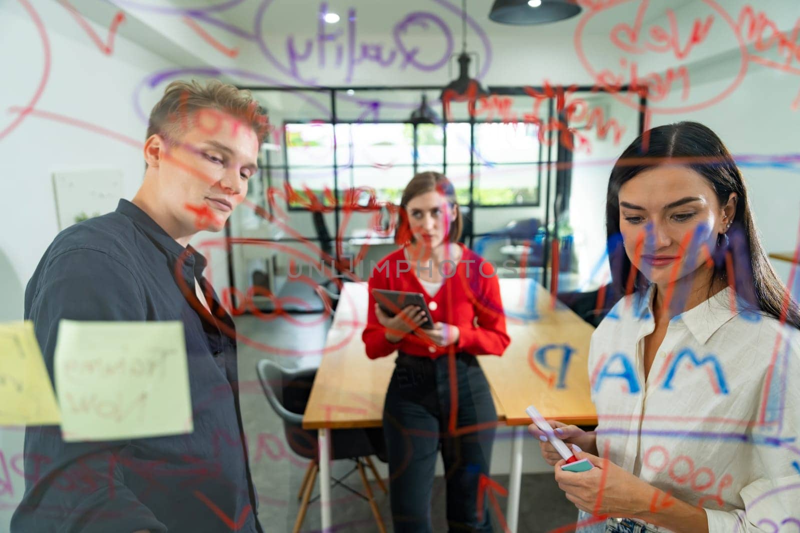 Creative business team brainstorming discussing and sharing marketing idea about start up project by using mind map colorful sticky note at glass board meeting room. Working together. Immaculate.