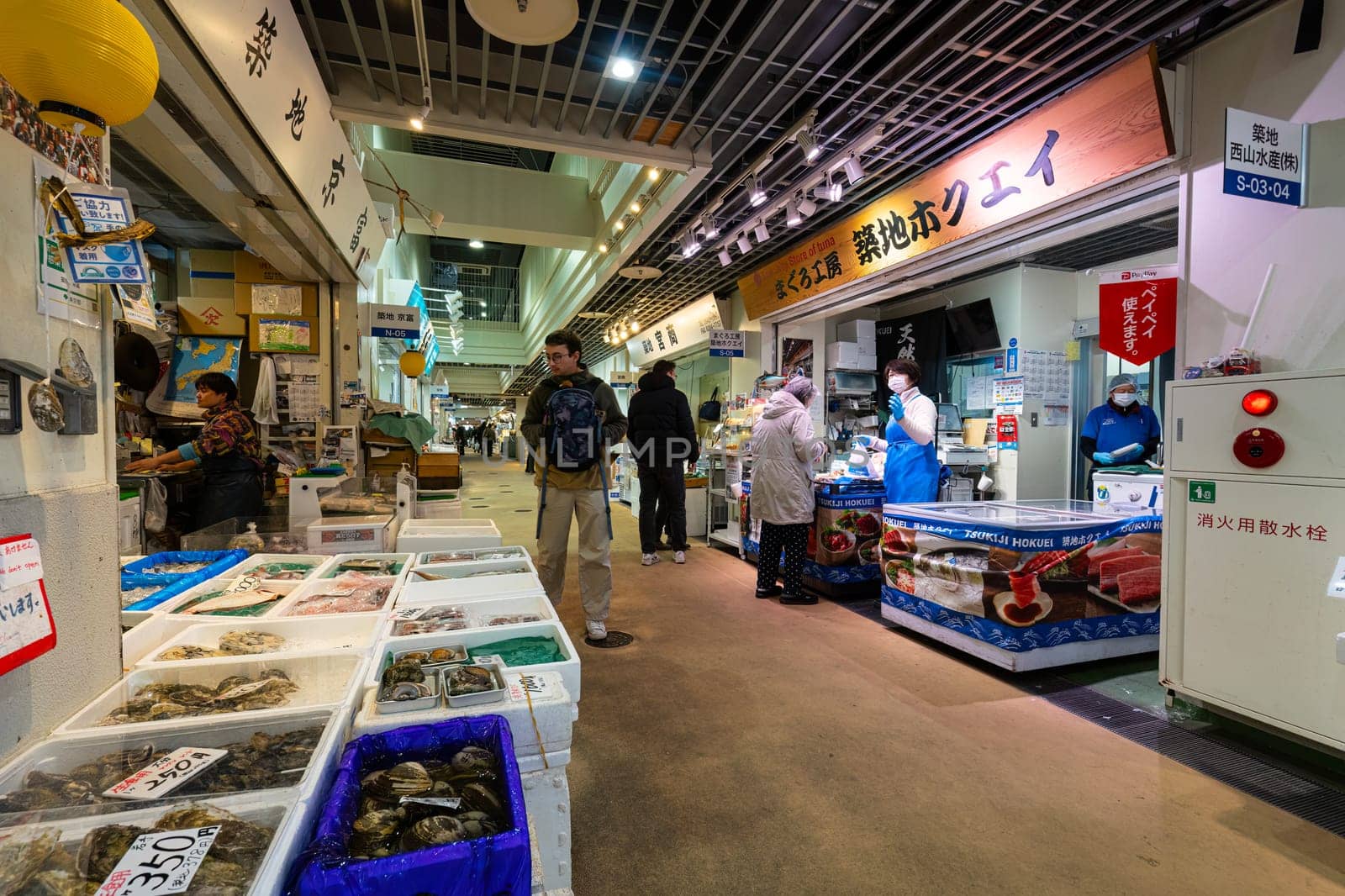 Tokyio, Japan. January 2024. People among stalls selling fresh fish at the Tsukiji Outer Market in the city centre
