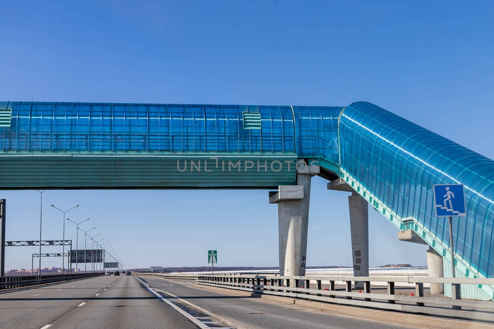 pedestrian crossing over to overpass.modern overhead crosswalk over an expressway.Convenience and safety for pedestrians.Big crosswalk over a busy highway.safety, traffic laws, highway by YuliaYaspe1979