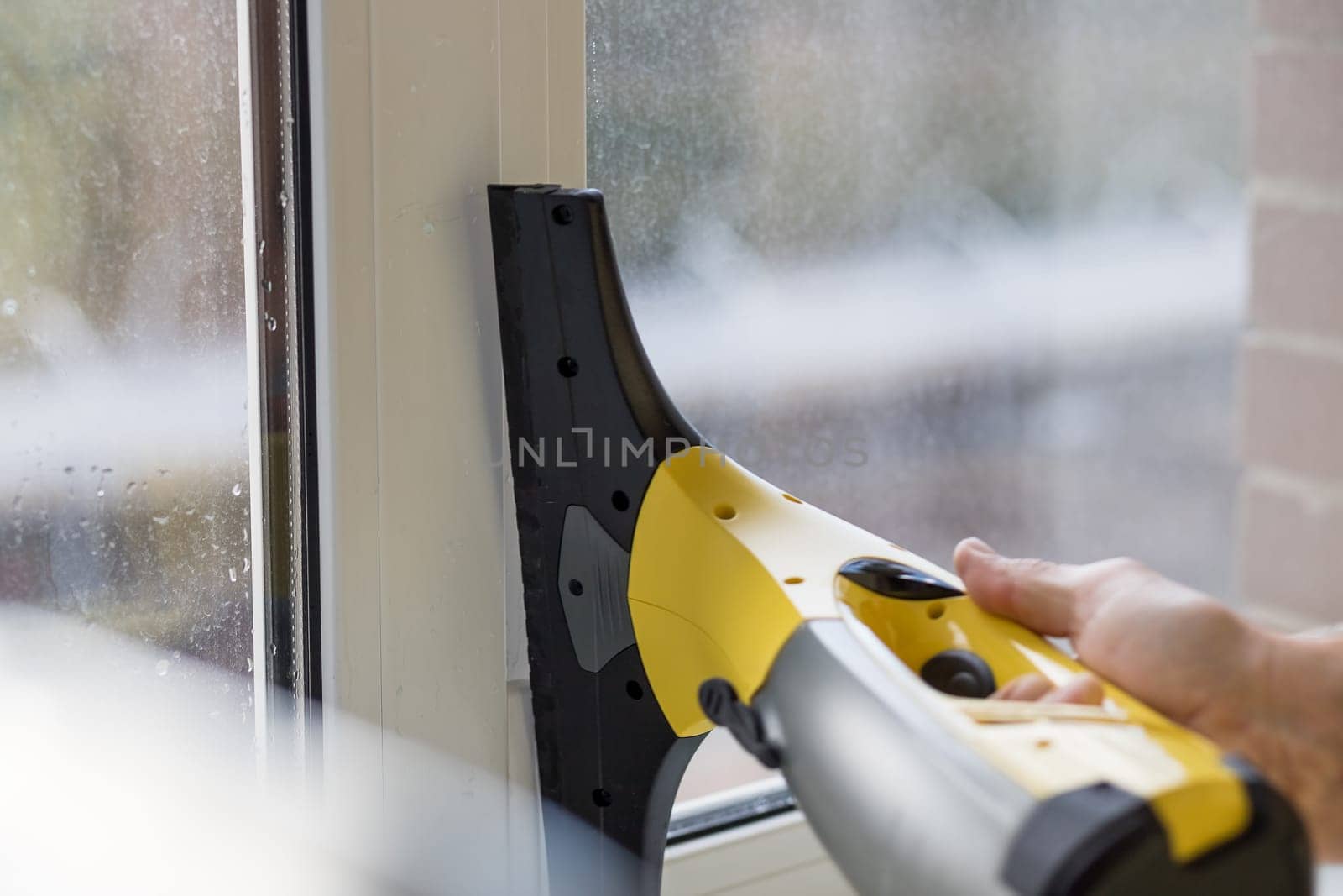 Cleaning windows with electric vacuum cleaner. Spring house cleaning- image