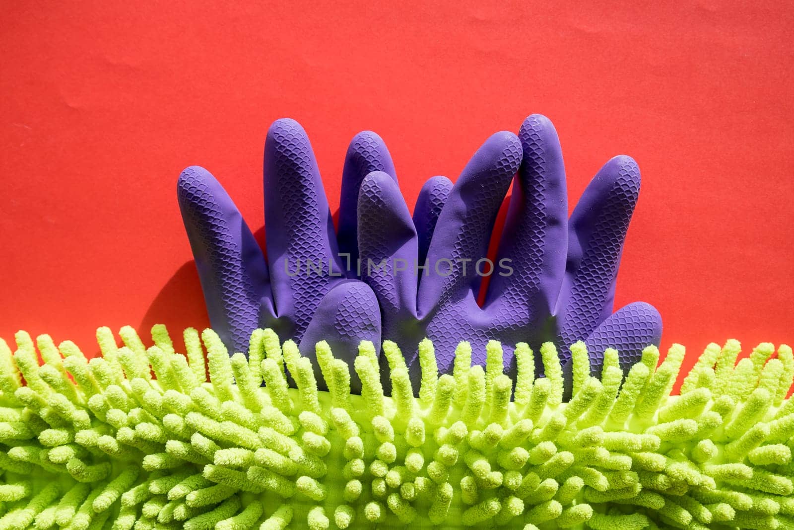 Cleaning kit isolated on red background. Set of napkins, rubber gloves and sponges. Professional kit for cleaning the house. Composition of cleaning tools. by YuliaYaspe1979