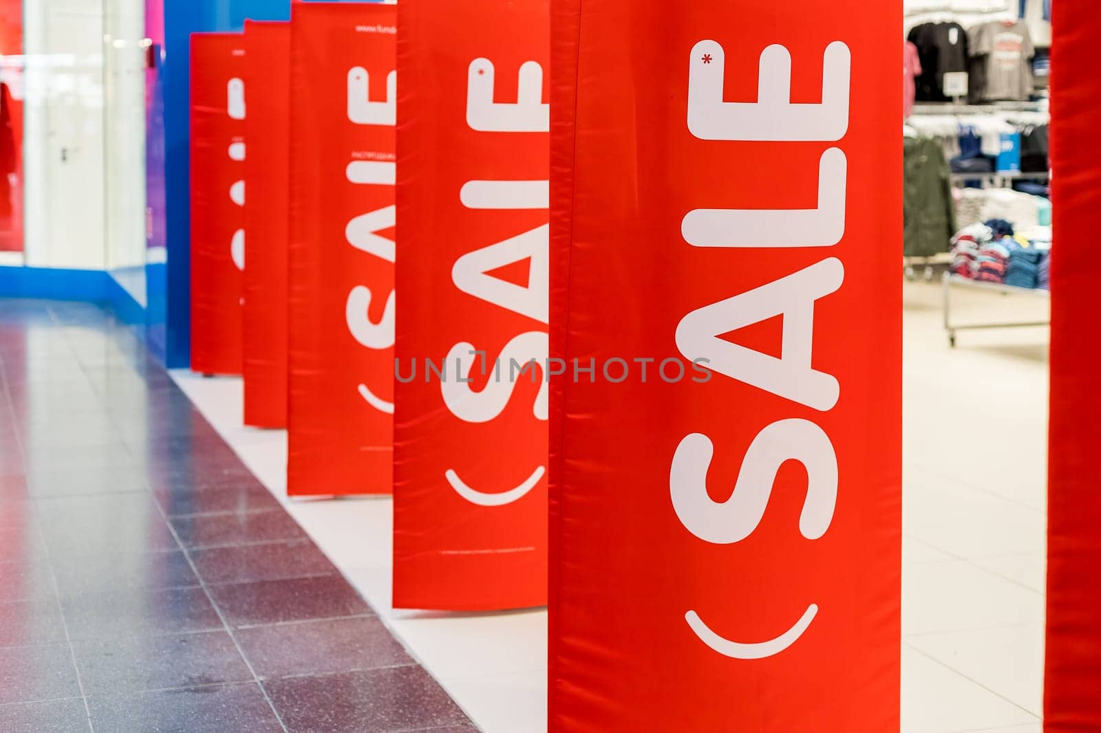 Big red sales poster on entrance clothing retailer.Discount sale label at shop entrance. Sale up to 50 percent.shopping mall.Season sale, black friday and shopping concept by YuliaYaspe1979