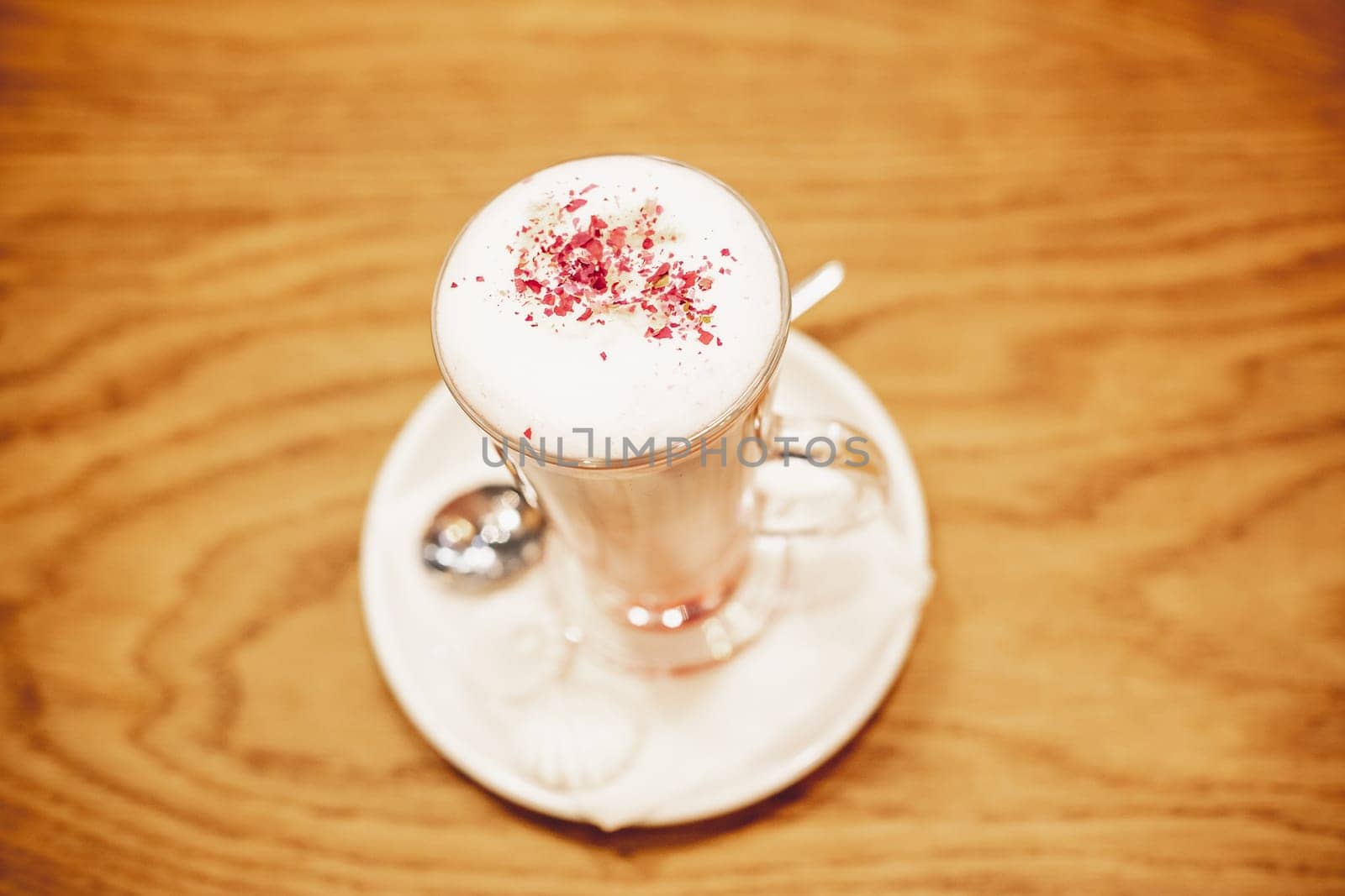 Frothy, layered cappuccino in a clear glass mug with cinnamon sprinkled on top