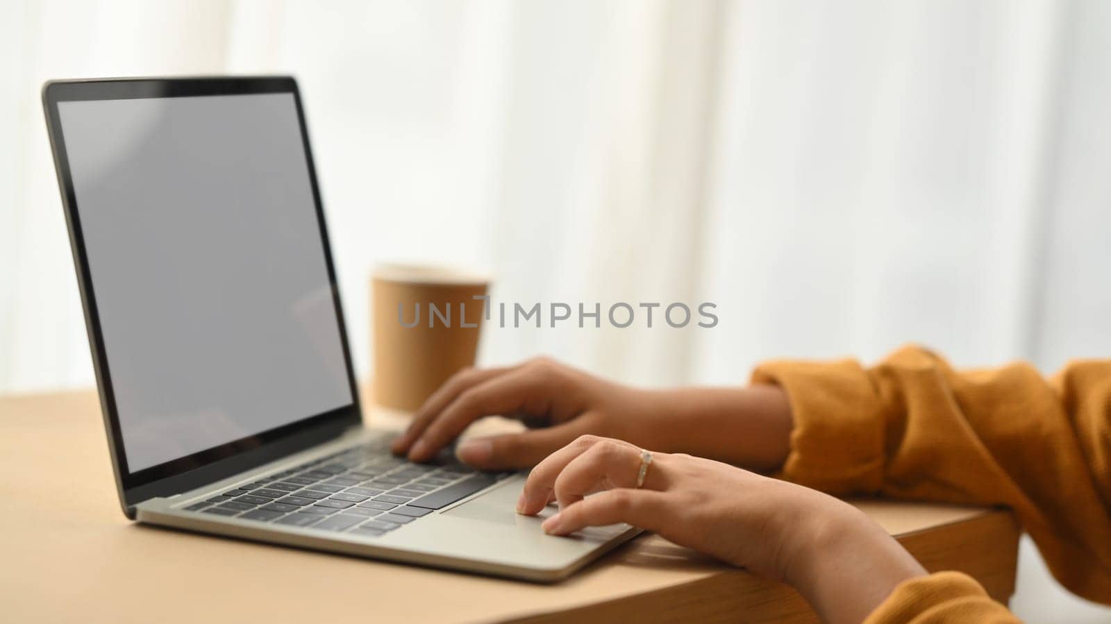 Cropped shot of young female freelancer working with digital tablet on desk at home by prathanchorruangsak