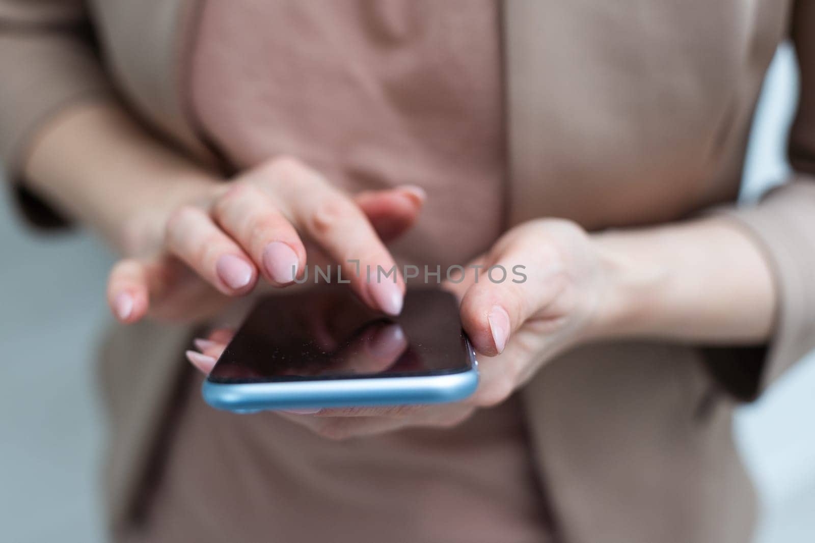 A businesswoman is holding mobile phone - on white background by Andelov13