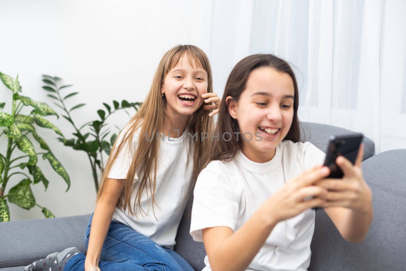 Children play with a mobile phone at home by Andelov13