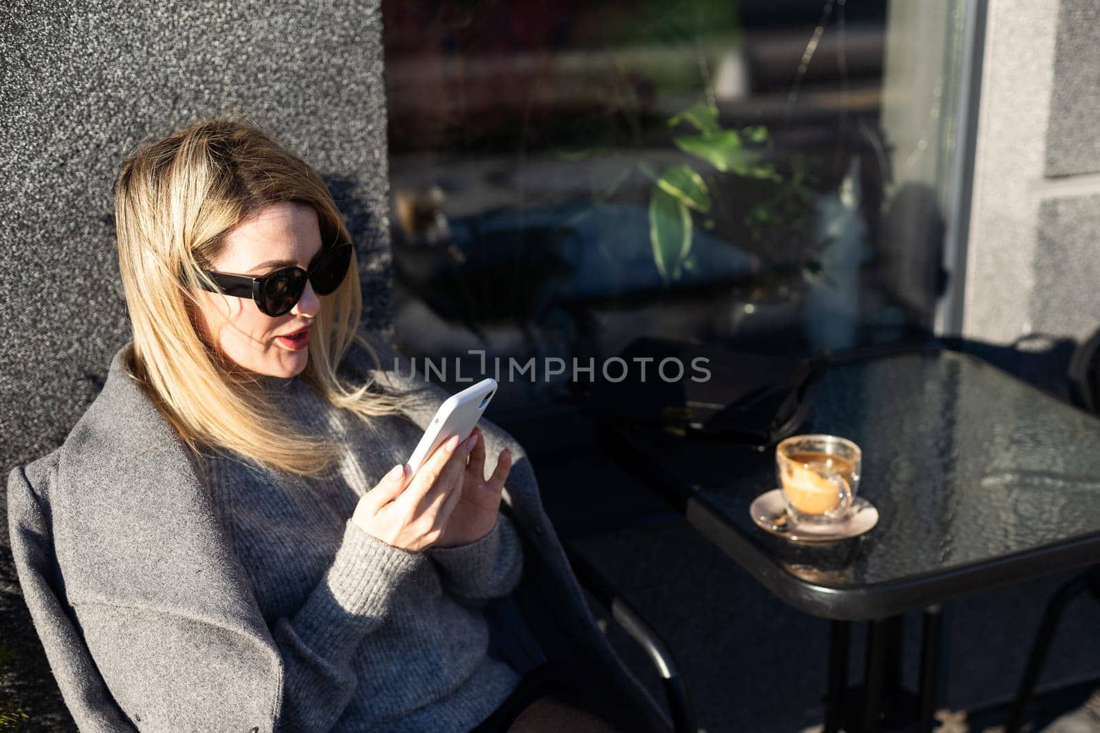 Young caucasian woman business woman drinks coffee at coffee shop terrace. High quality photo