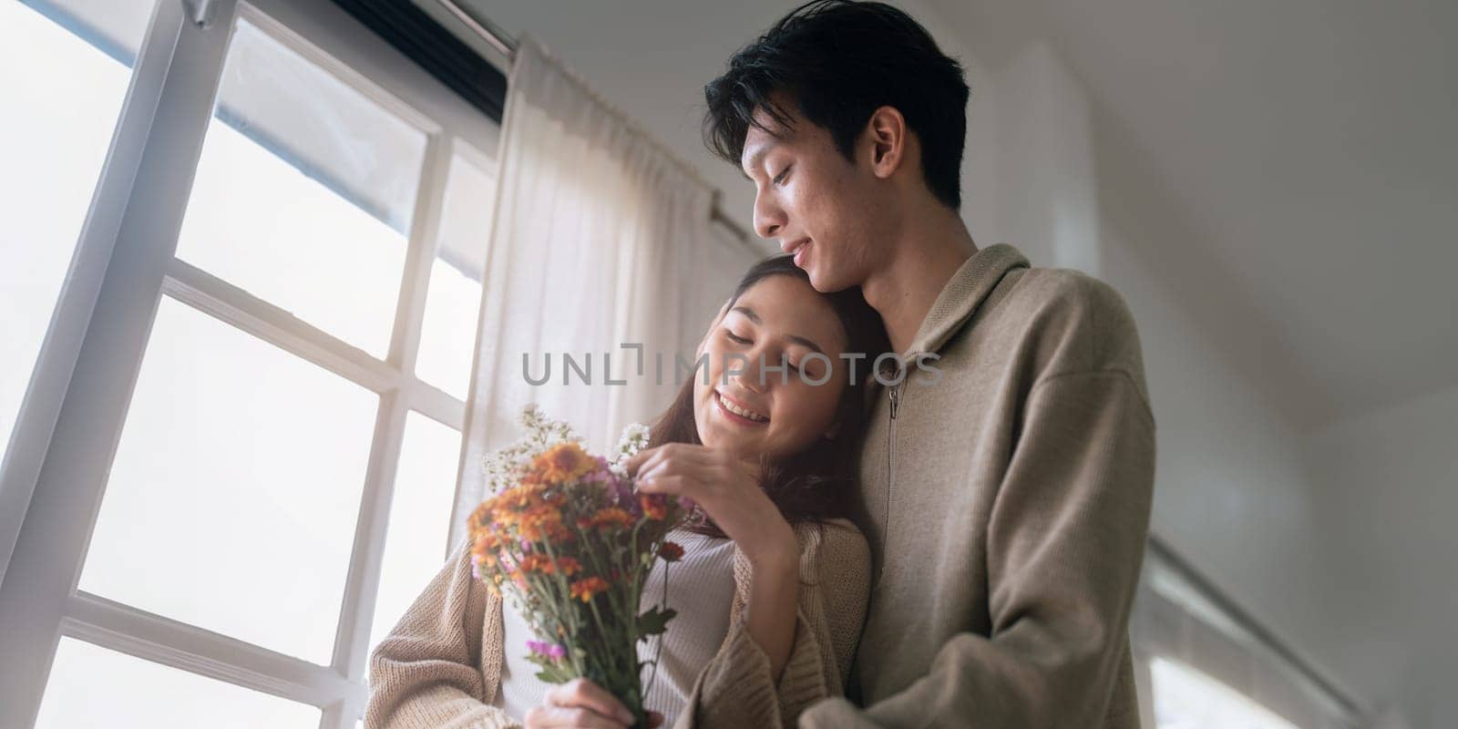 Young couple Hug and giving flower on Valentine's Day. Romantic day together. Valentine's Day concept.