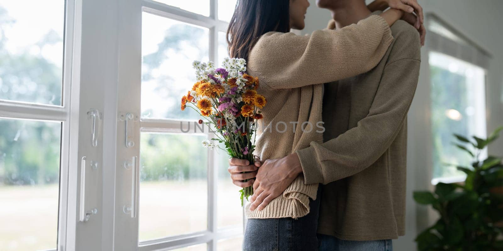 Young couple Hug and giving flower on Valentine's Day. Romantic day together. Valentine's Day concept.