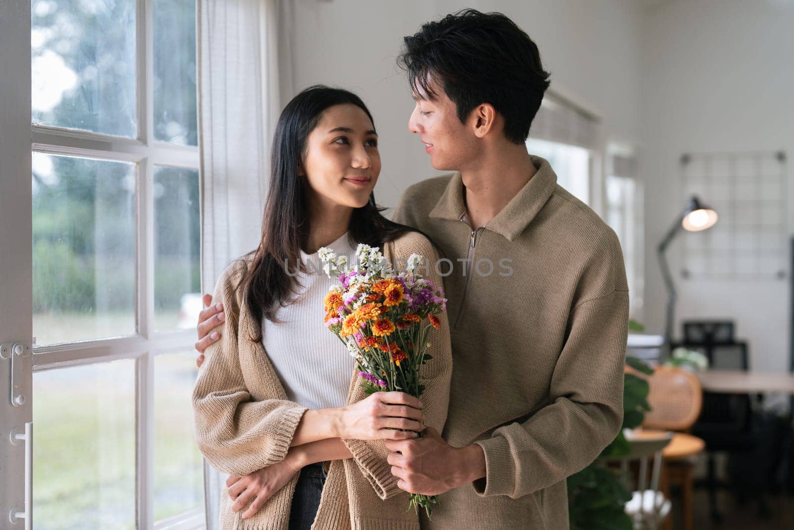 Young couple Hug and giving flower on Valentine's Day. Romantic day together. Valentine's Day concept.