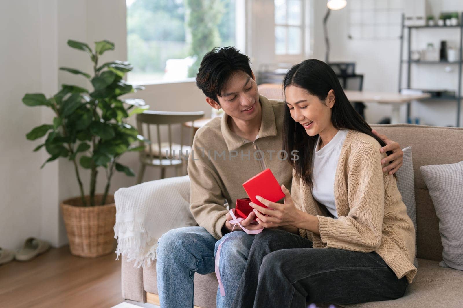 Young couple celebrating and giving present on Valentine's Day. Romantic day together. Valentine's Day concept.