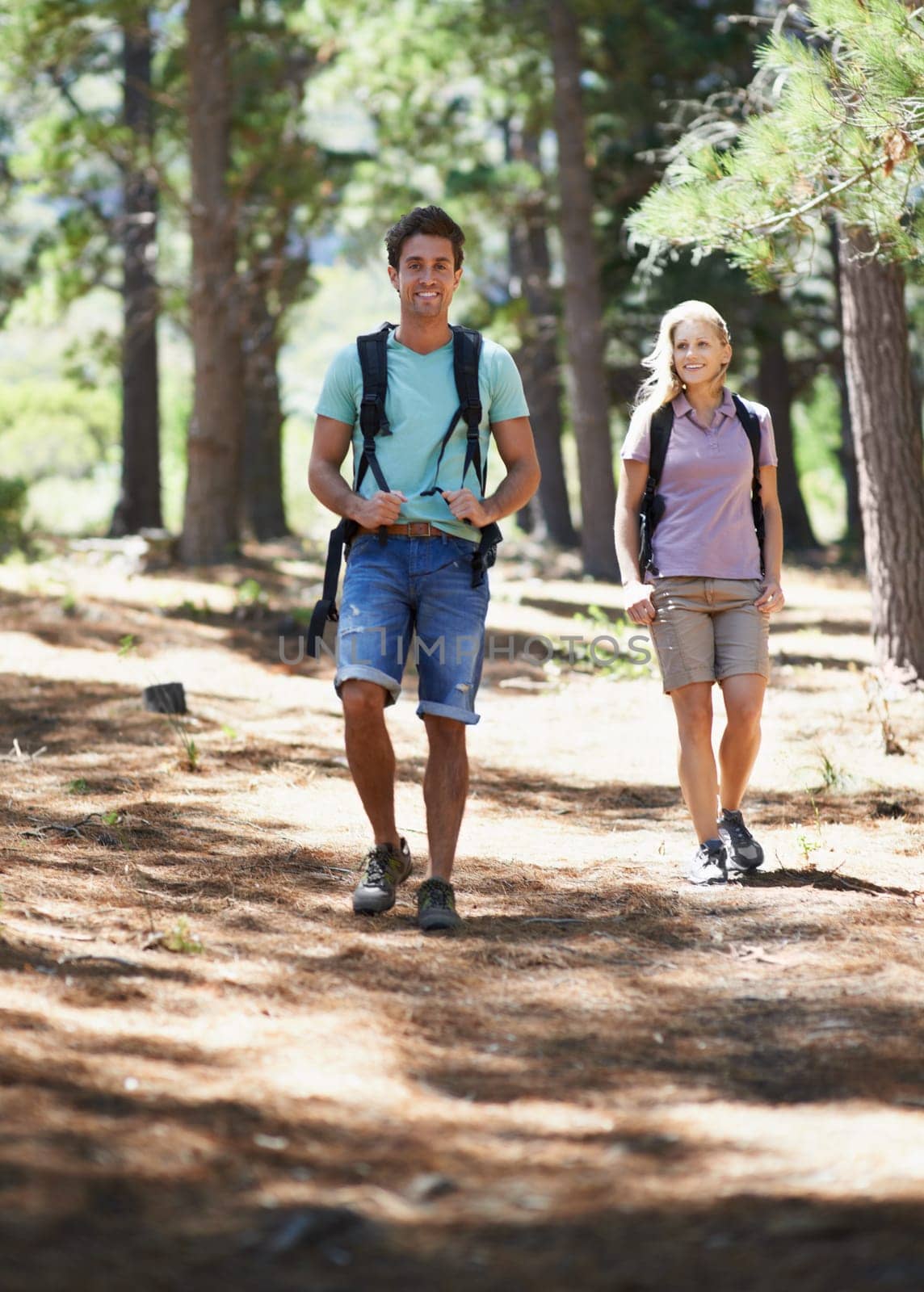 Couple of friends, travel and hiking in forest for fitness, outdoor adventure and wellness or health in nature. Portrait of happy man and woman walking and trekking with backpack on path and journey by YuriArcurs