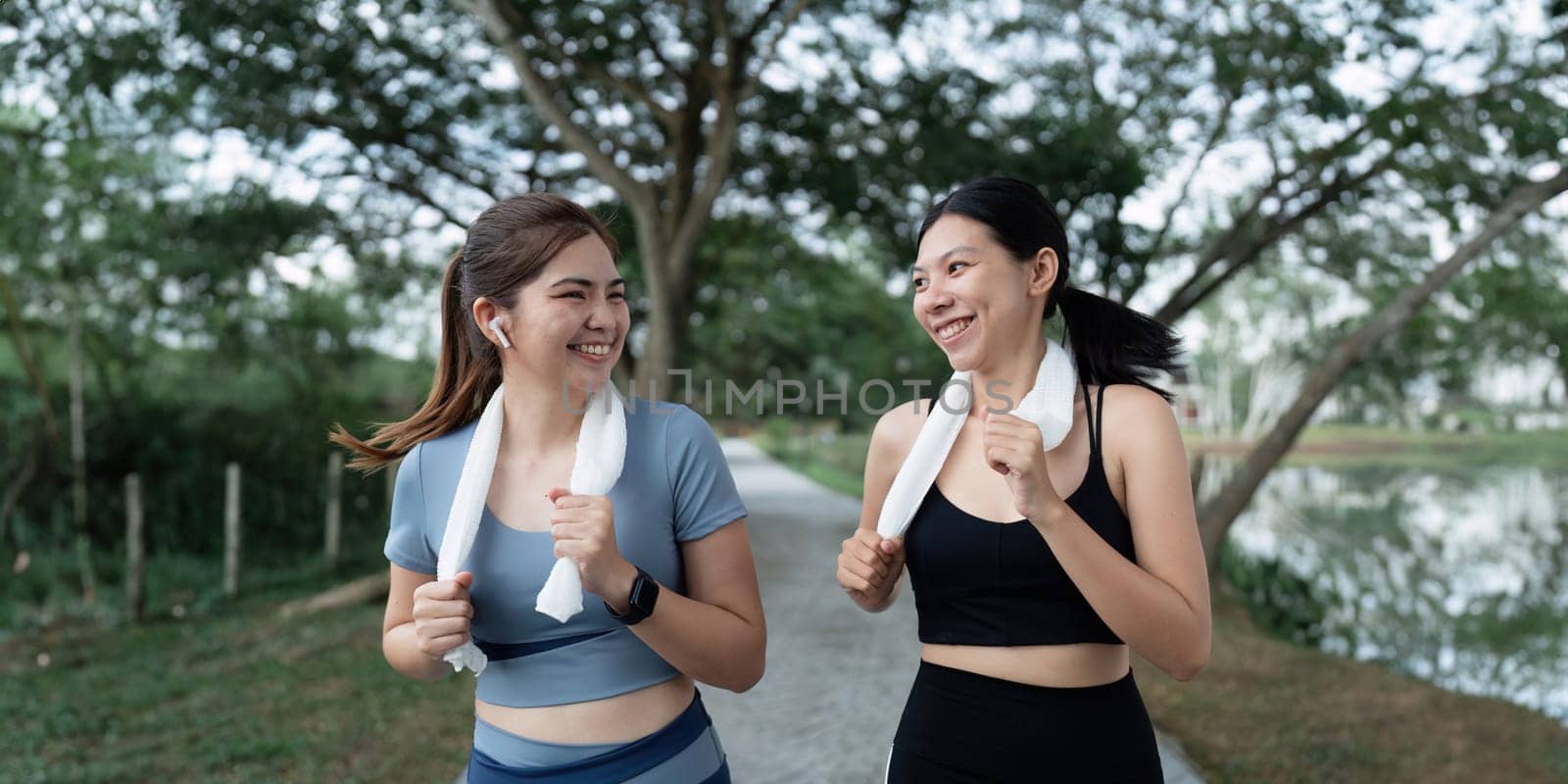 Two happy women going for sunrise running. Women in track suits running at park by itchaznong