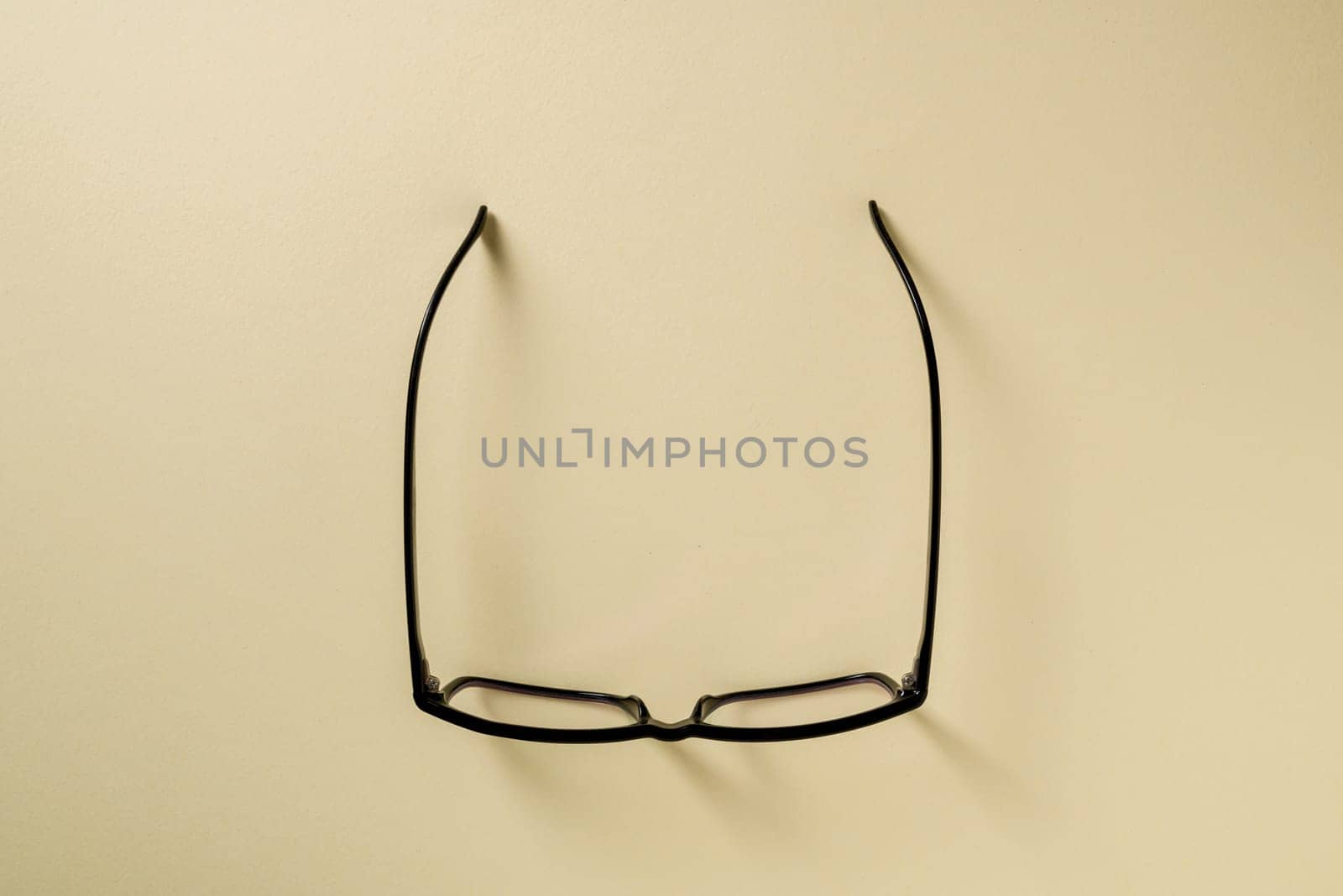 Prescription glasses with black frames on a yellow background by Sonat