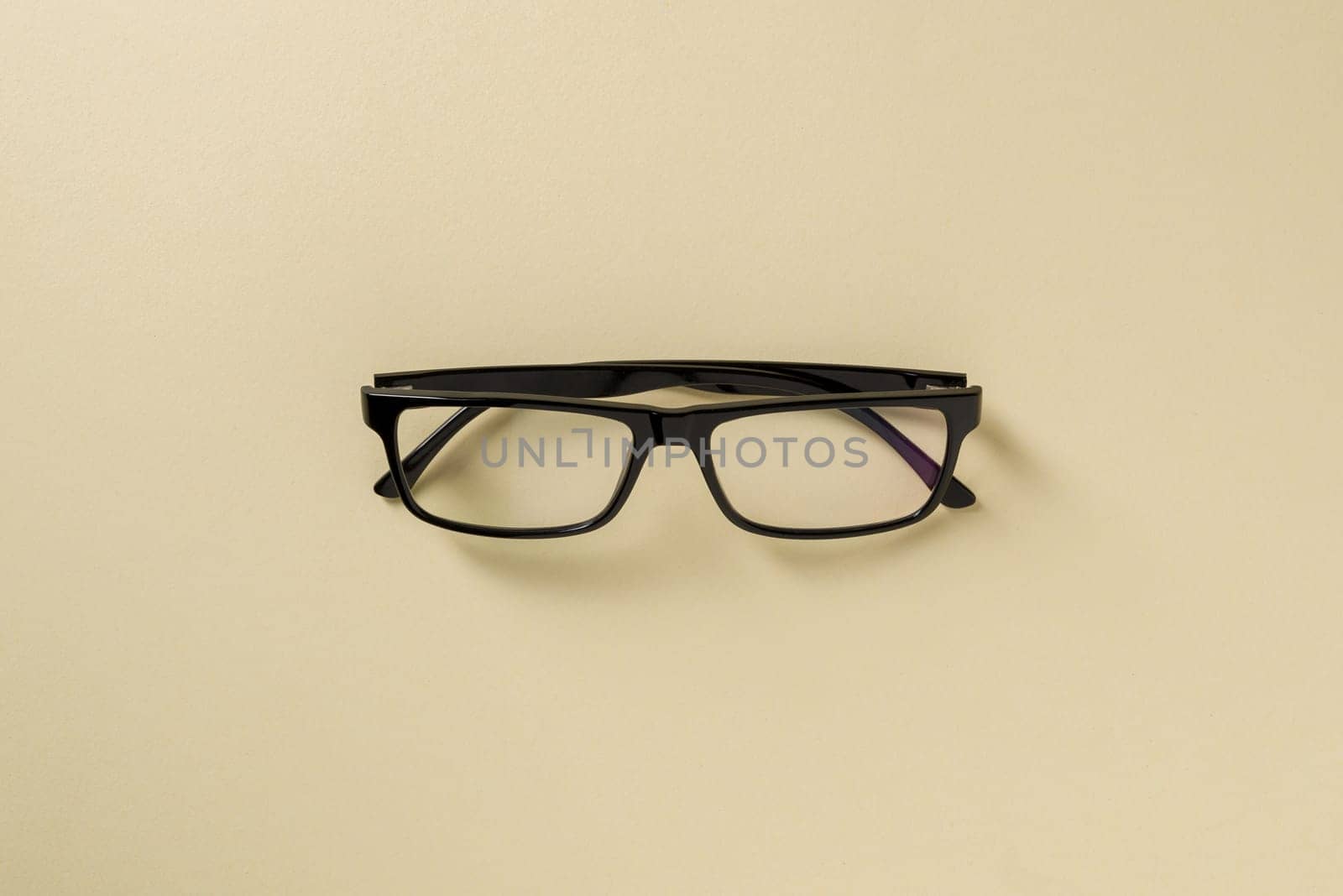 Prescription glasses with black frames on a yellow background