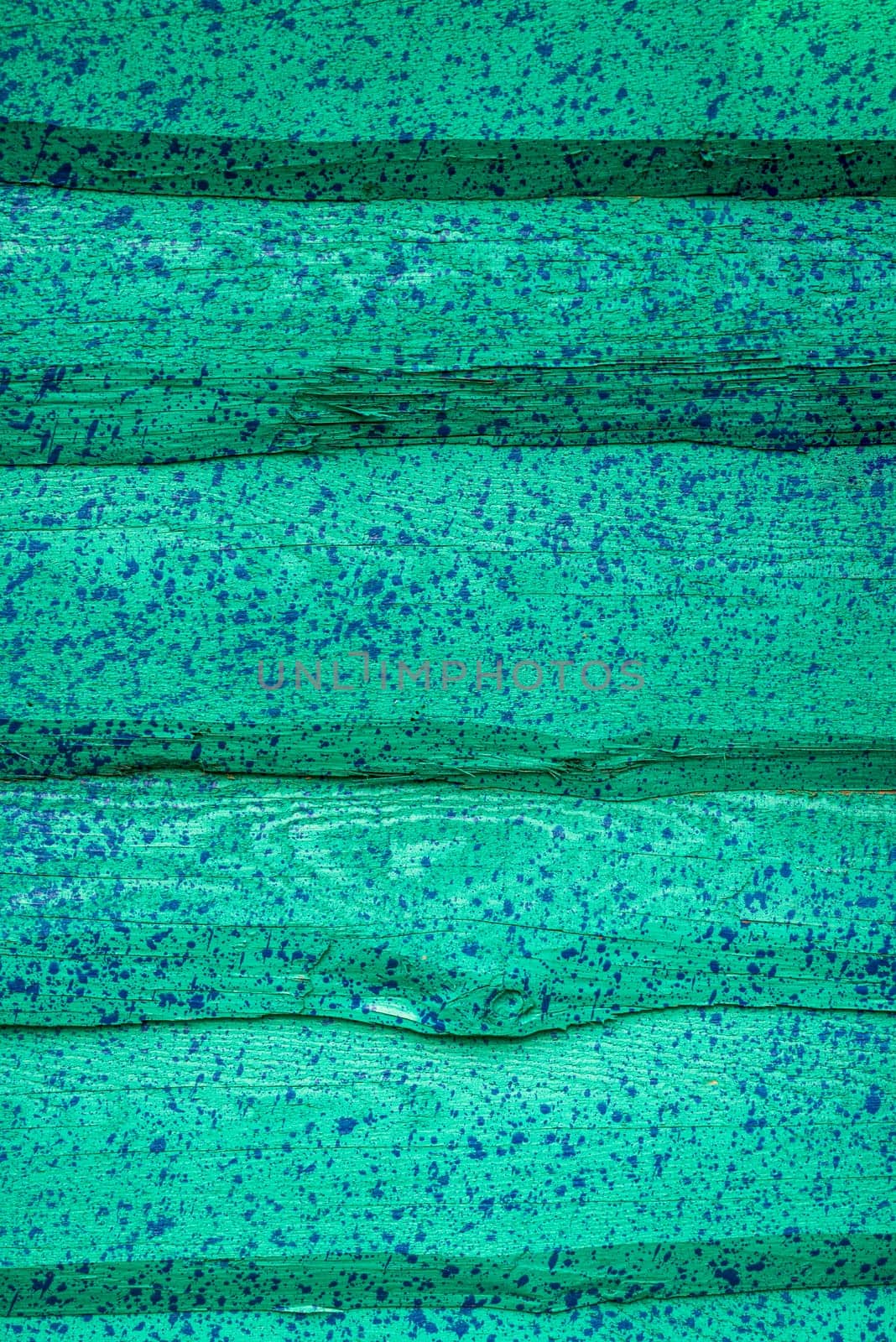 decorative wooden house wall painted green and splashed with blue paint