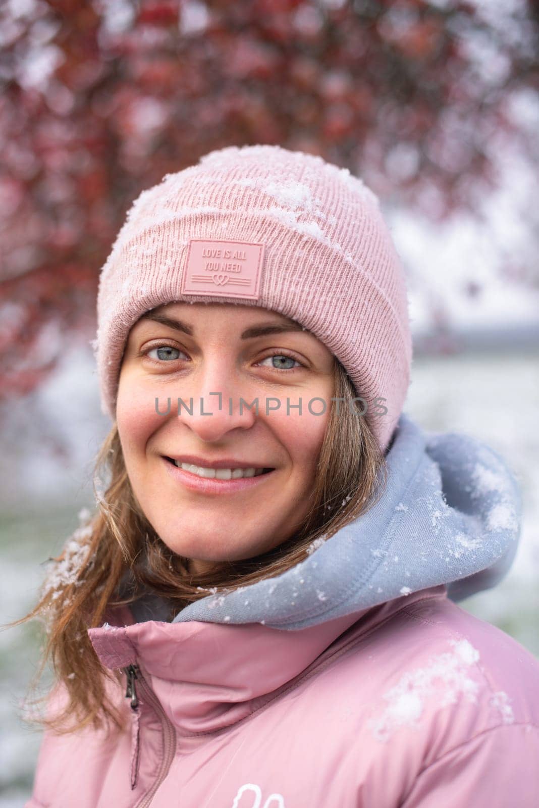 Winter Elegance: Portrait of a Beautiful Girl in a Snowy European Village. Winter lifestyle portrait of cheerful pretty girl. Smiling and having fun in the snow park. Snowflakes falling down. Christmas Radiance: Capturing Winter Elegance in the Snowy Ambiance of a European Village by Andrii_Ko