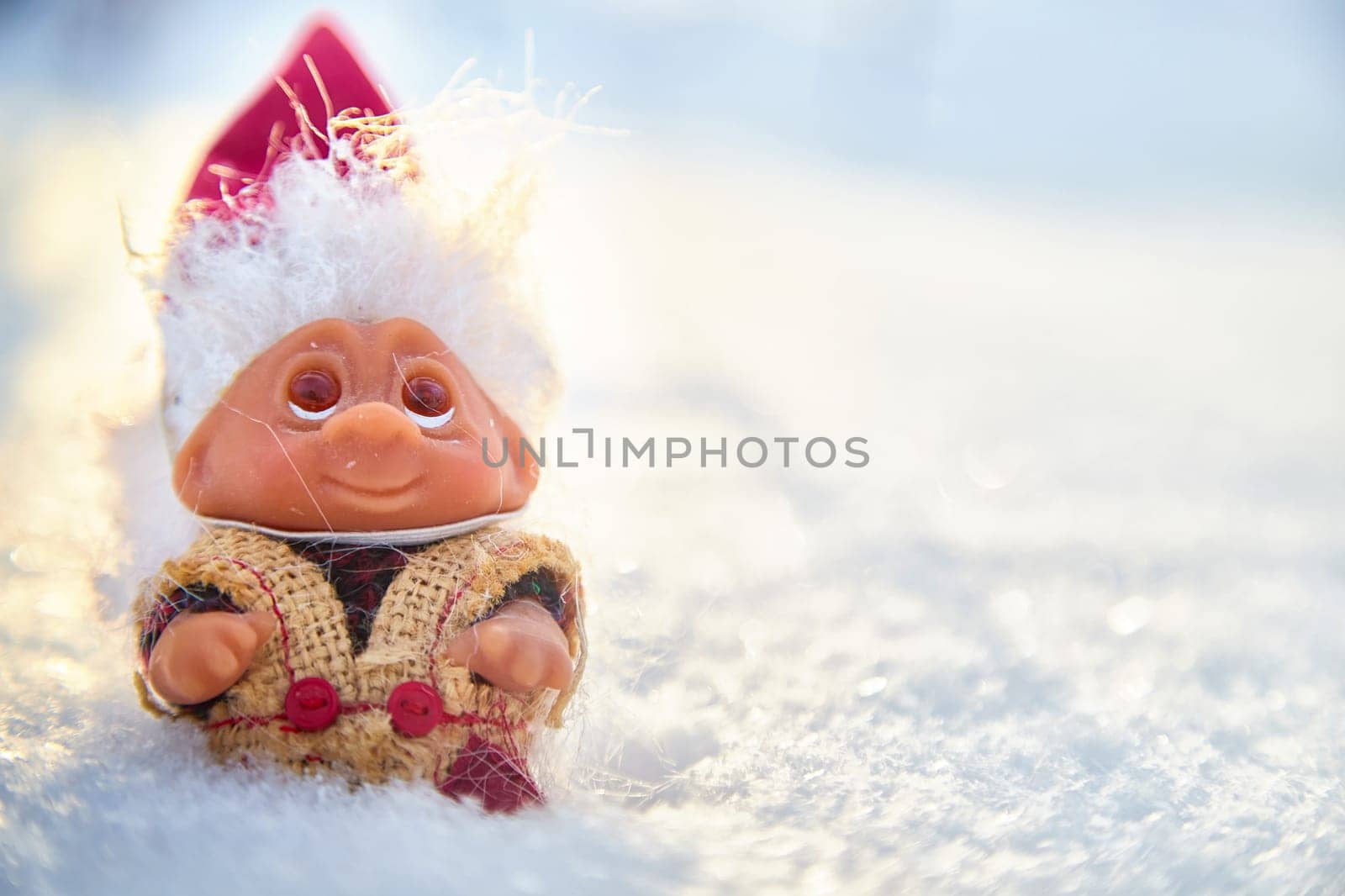Cute little funny dwarf in the snow in the landscape in winter. Wizard on a snowy background. Christmas and New Year