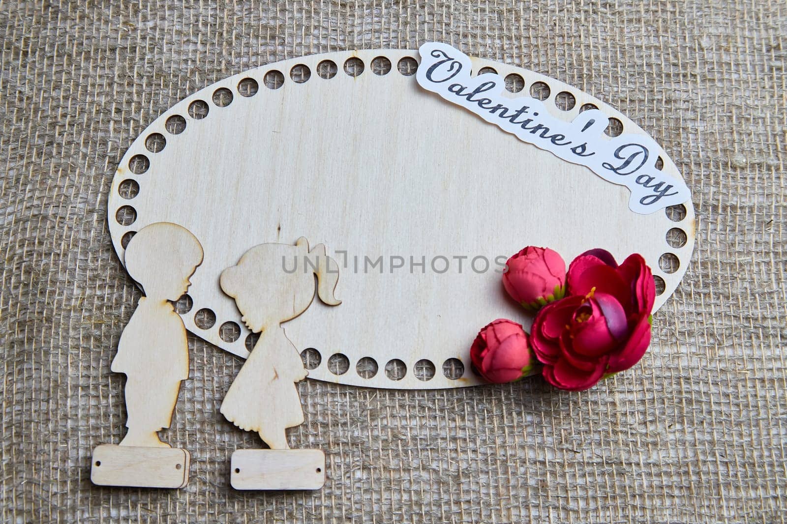 Wooden figurines of couple, inscription Valentine's Day, red flowers. Concept of holiday of love. Background, texture, frame, place for text, copy space