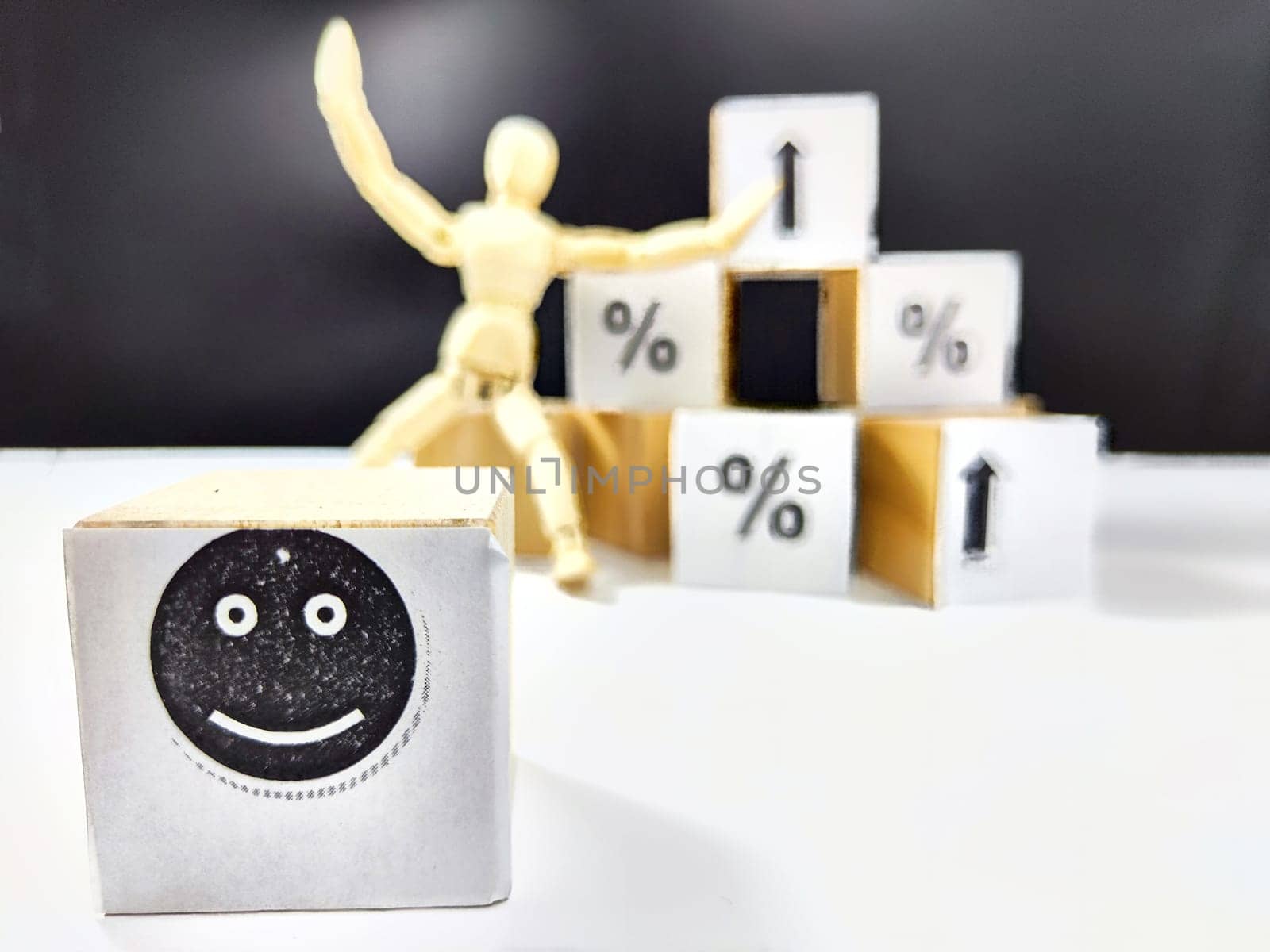 Wooden cubes in a column and row with white signs with a smiley sign, an arrow, a percentage. The concept of positivism. Positive thinking leads to the achievement of results and profits