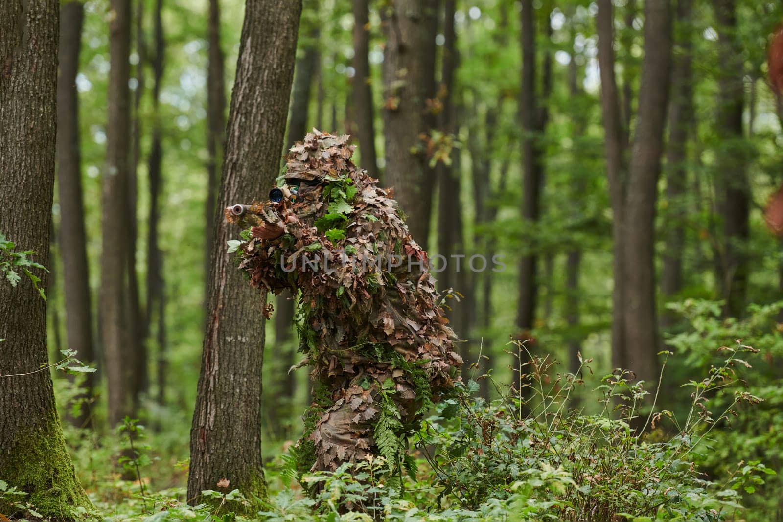 A highly skilled elite sniper, camouflaged in the dense forest, stealthily maneuvers through dangerous woodland terrain on a covert and precise mission.