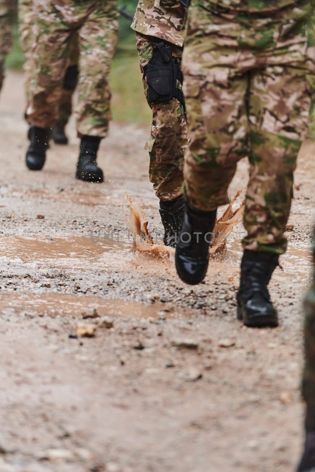 Close up photo, the resilient legs of elite soldiers, clad in camouflage boots, stride purposefully along a hazardous forest path as they embark on a high-stakes military mission by dotshock
