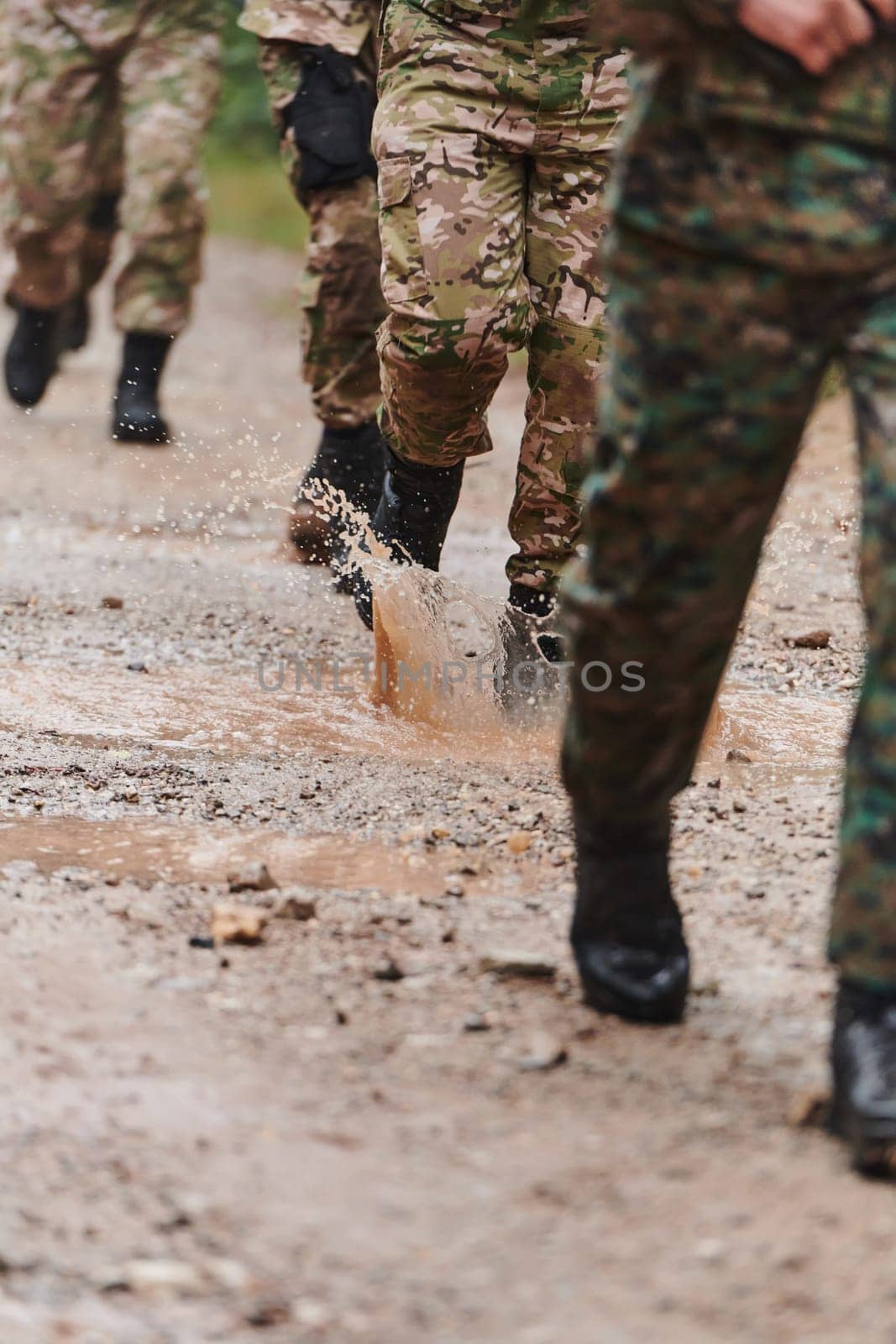 Close up photo, the resilient legs of elite soldiers, clad in camouflage boots, stride purposefully along a hazardous forest path as they embark on a high-stakes military mission.