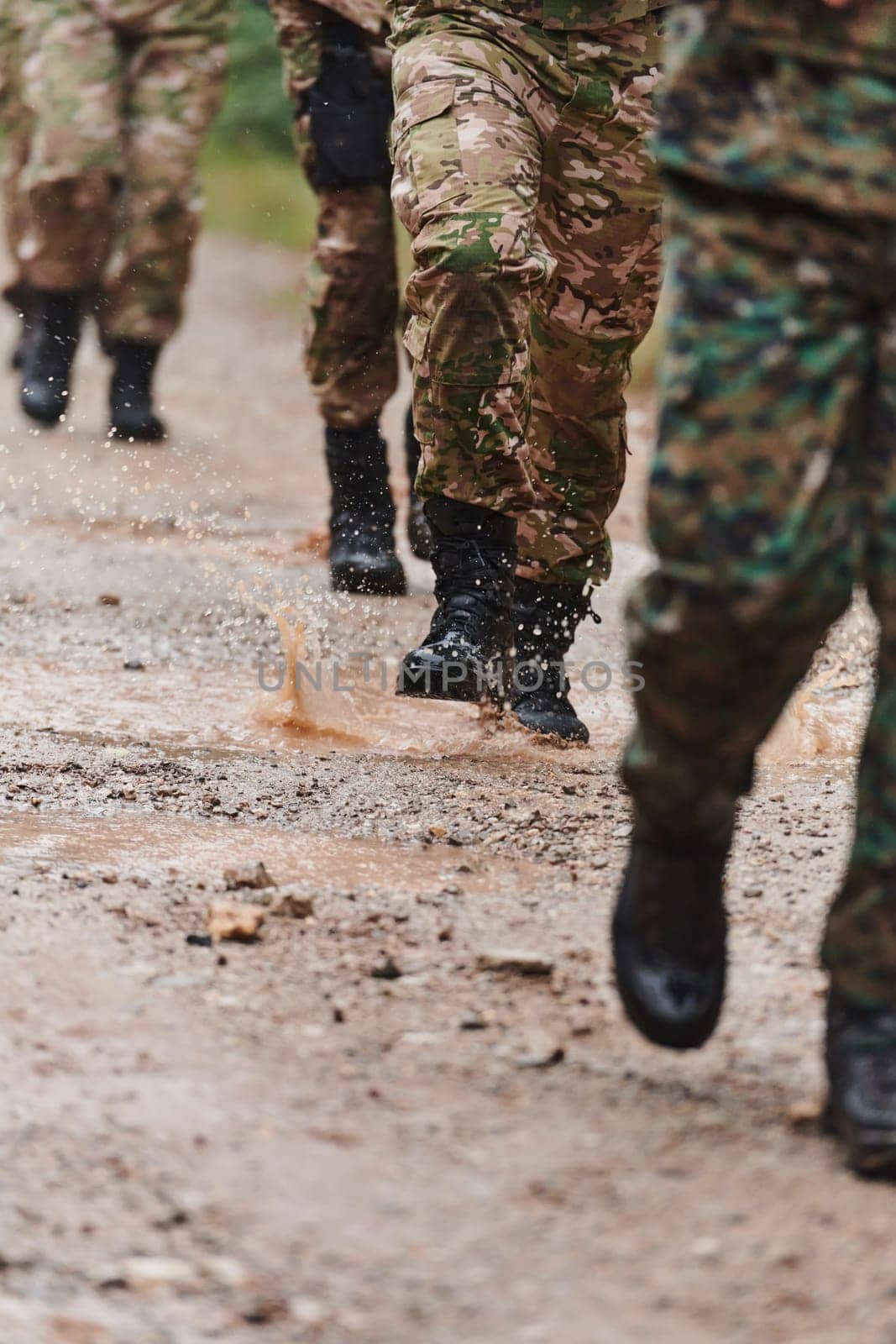 Close up photo, the resilient legs of elite soldiers, clad in camouflage boots, stride purposefully along a hazardous forest path as they embark on a high-stakes military mission.