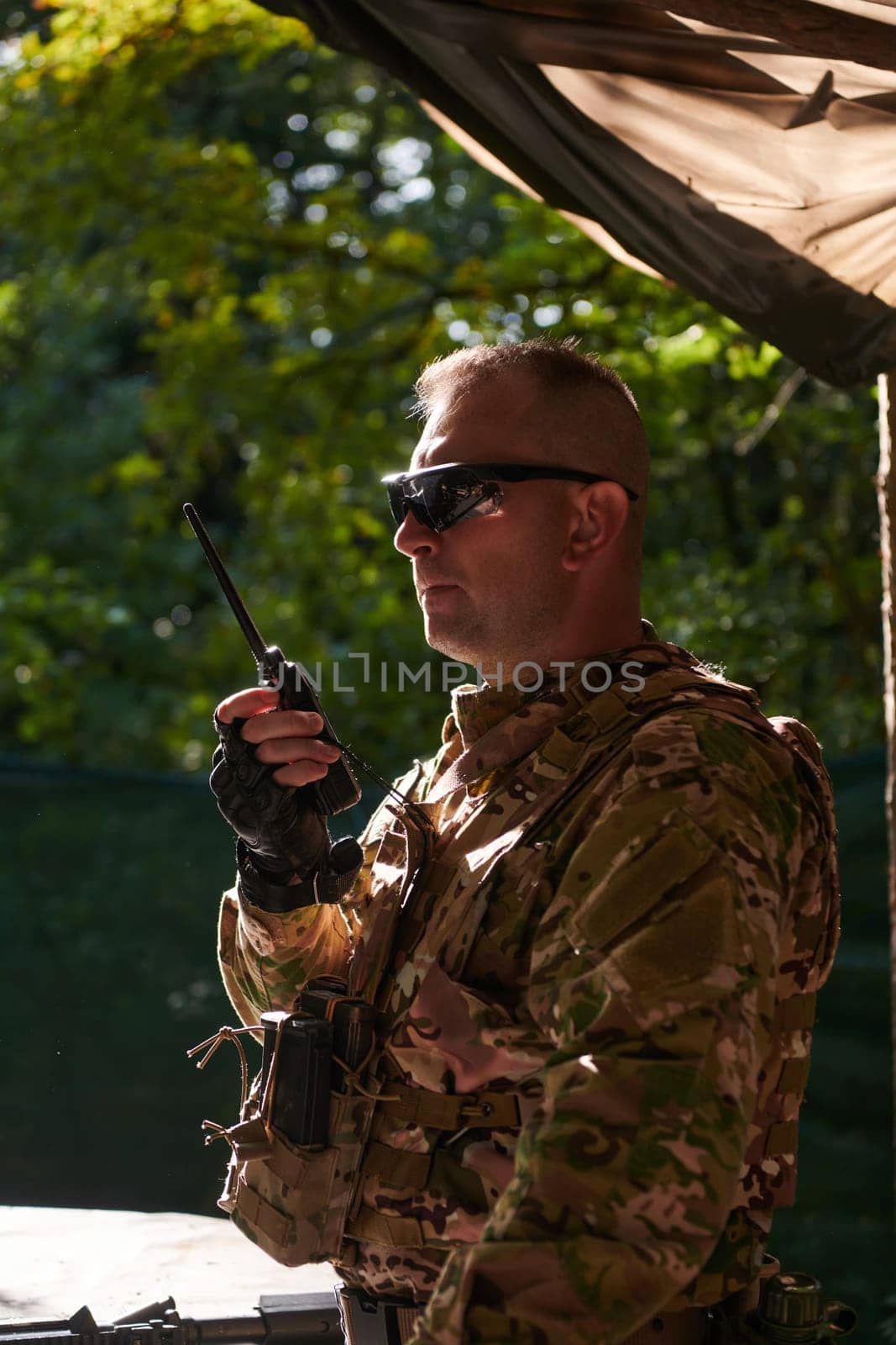 A military major employs a Motorola radio for seamless communication with his fellow soldiers during a tactical operation, showcasing professionalism and strategic coordination by dotshock